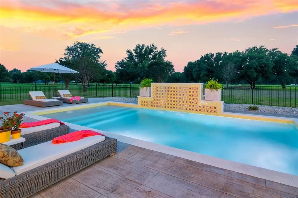 Pool at dusk featuring a patio area