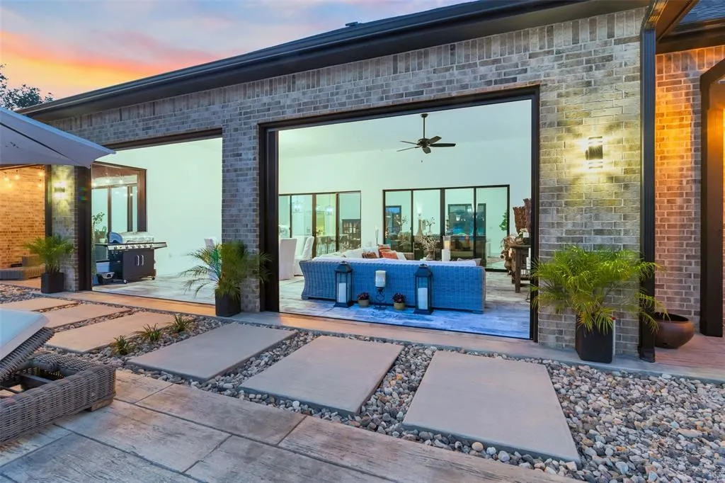 Exterior entry at dusk featuring an outdoor living space, a patio, and ceiling fan
