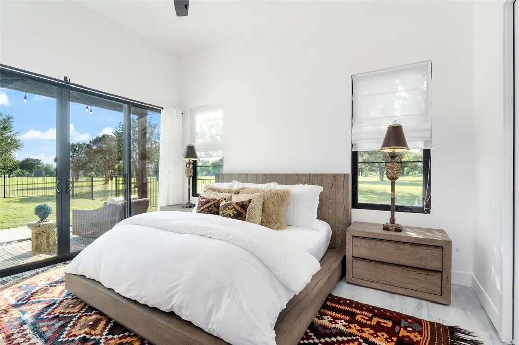 Bedroom featuring multiple windows, hardwood / wood-style flooring, and access to exterior