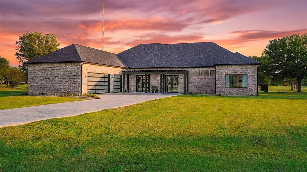 French country home featuring a garage and a yard