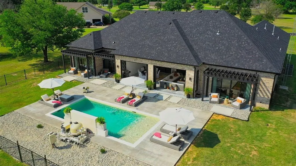 Rear view of property featuring a fenced in pool, an outdoor hangout area, a pergola, and a patio