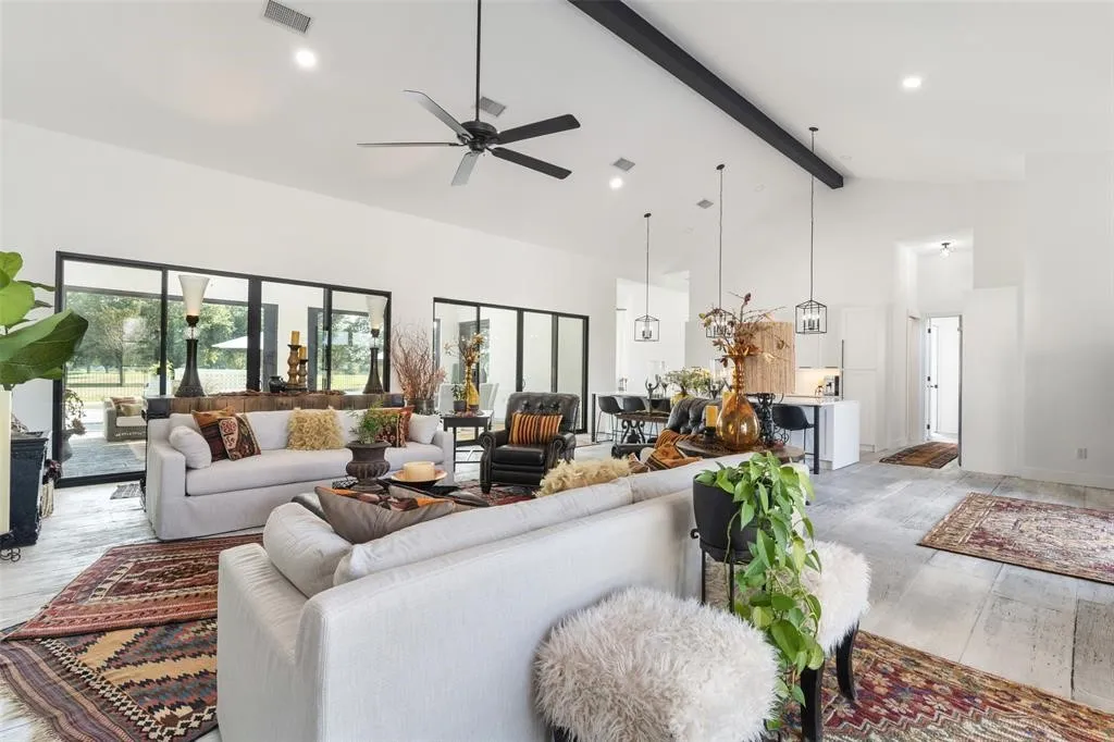 Living room featuring ceiling fan, beam ceiling, high vaulted ceiling, and light hardwood / wood-style flooring