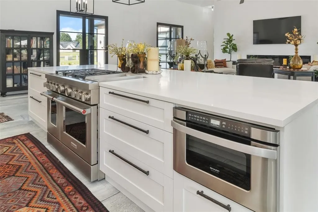 Kitchen with white cabinetry, double oven range, hanging light fixtures, and oven