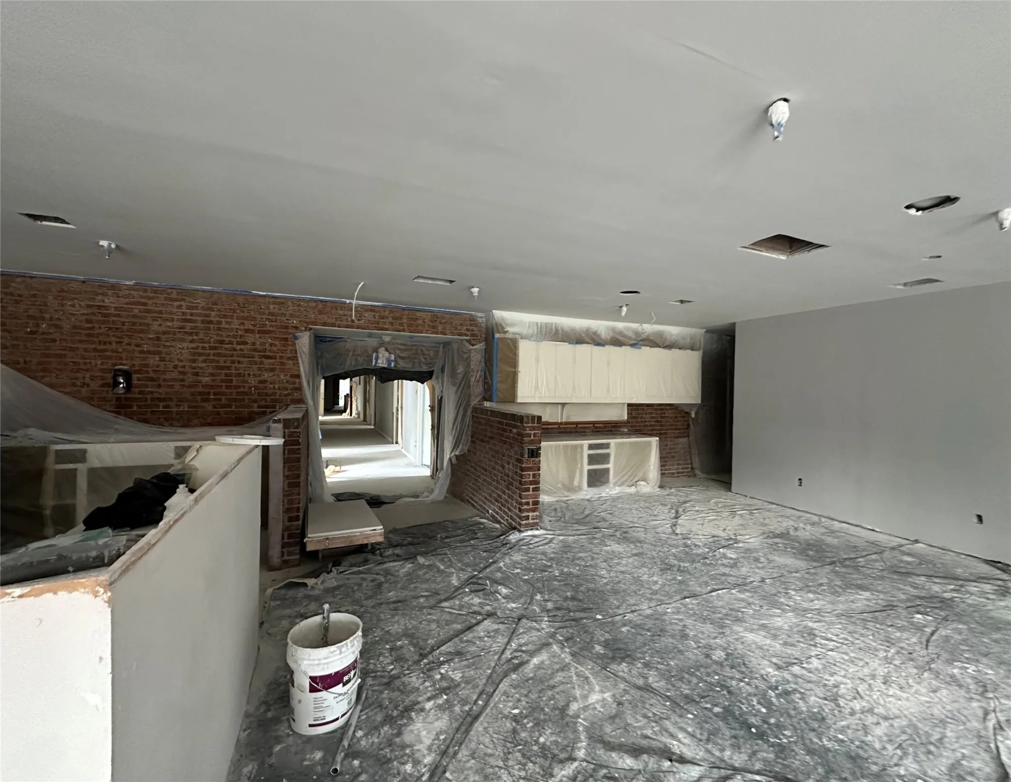 Unfurnished living room featuring brick wall