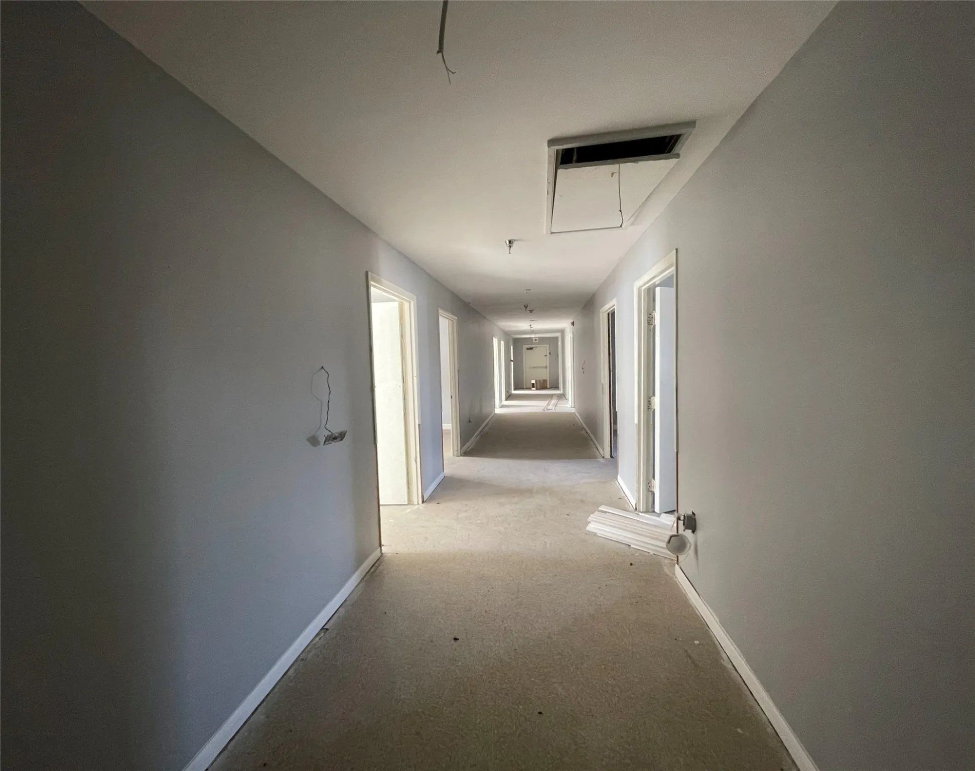 Corridor featuring light colored carpet