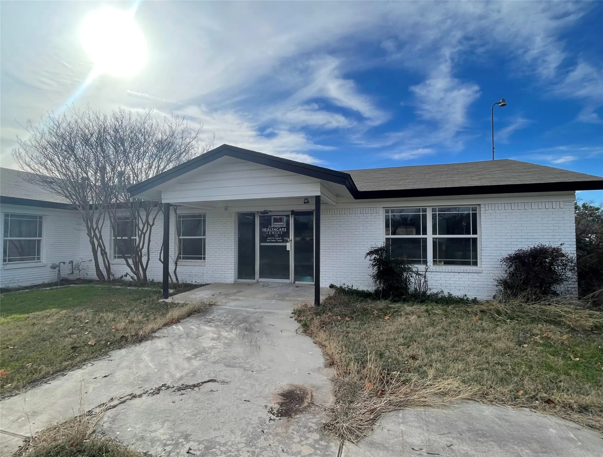 Ranch-style home featuring a front lawn and a carport
