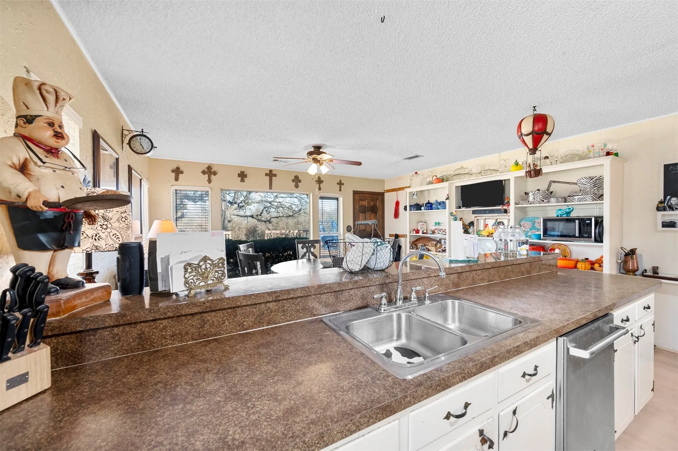 Kitchen featuring appliances with stainless steel finishes, a ceiling fan, white cabinets, a sink, and a textured​​‌​​​​‌​​‌‌​‌‌​​​‌‌​‌​‌​‌​​​‌​​ ceiling