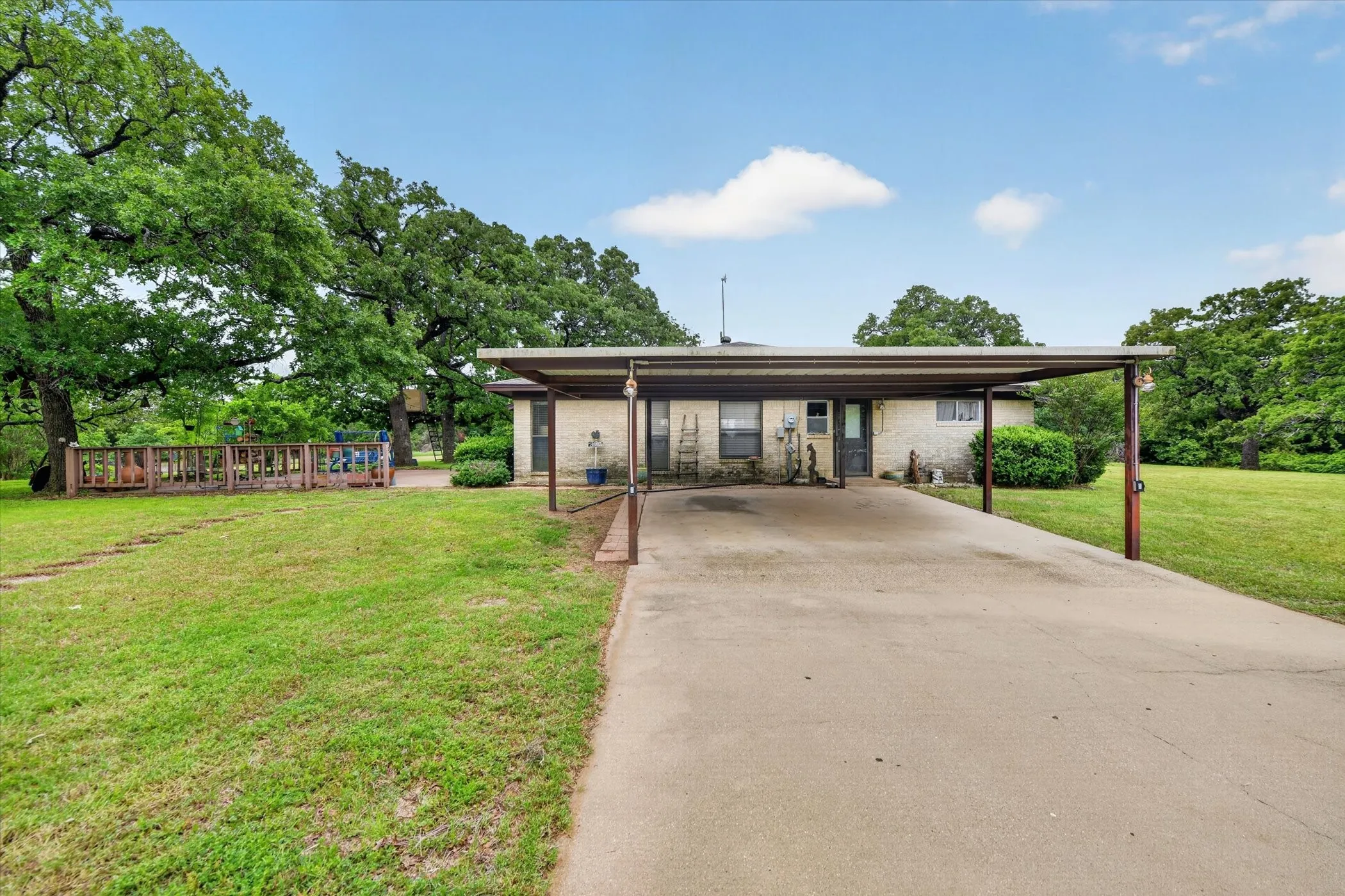 Ranch-style residence featuring a brick facade and a multi-car carport