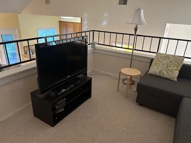 Living room featuring carpet, visible vents, and baseboards