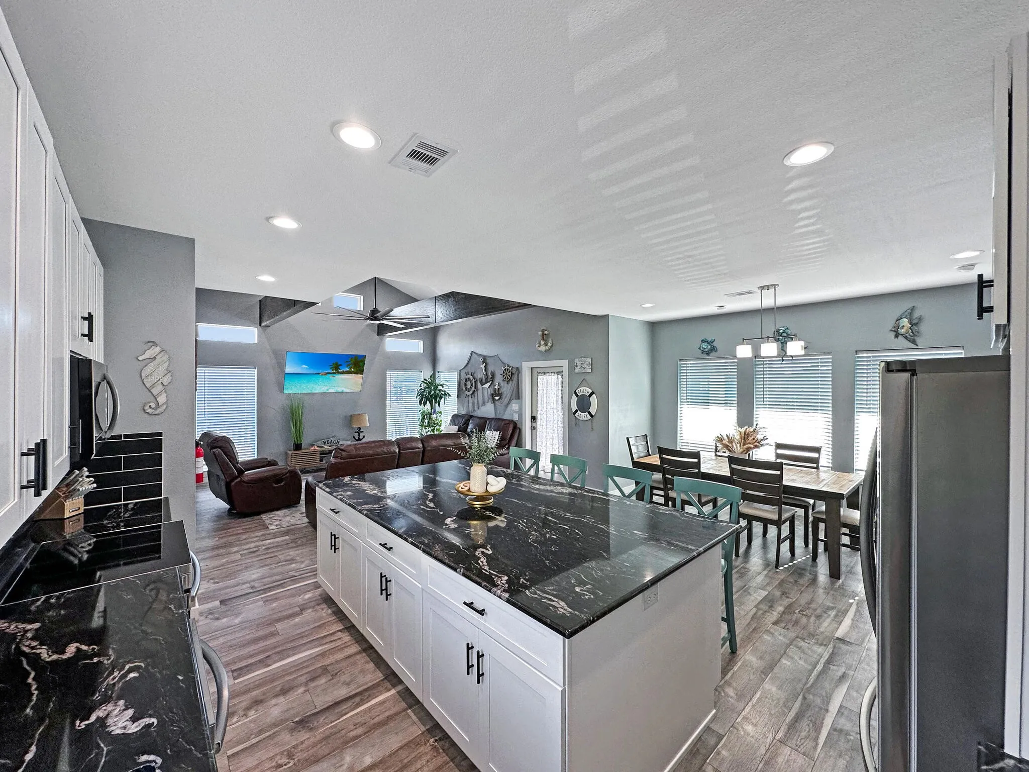 Kitchen featuring freestanding refrigerator, white cabinets,  and wood finished floors