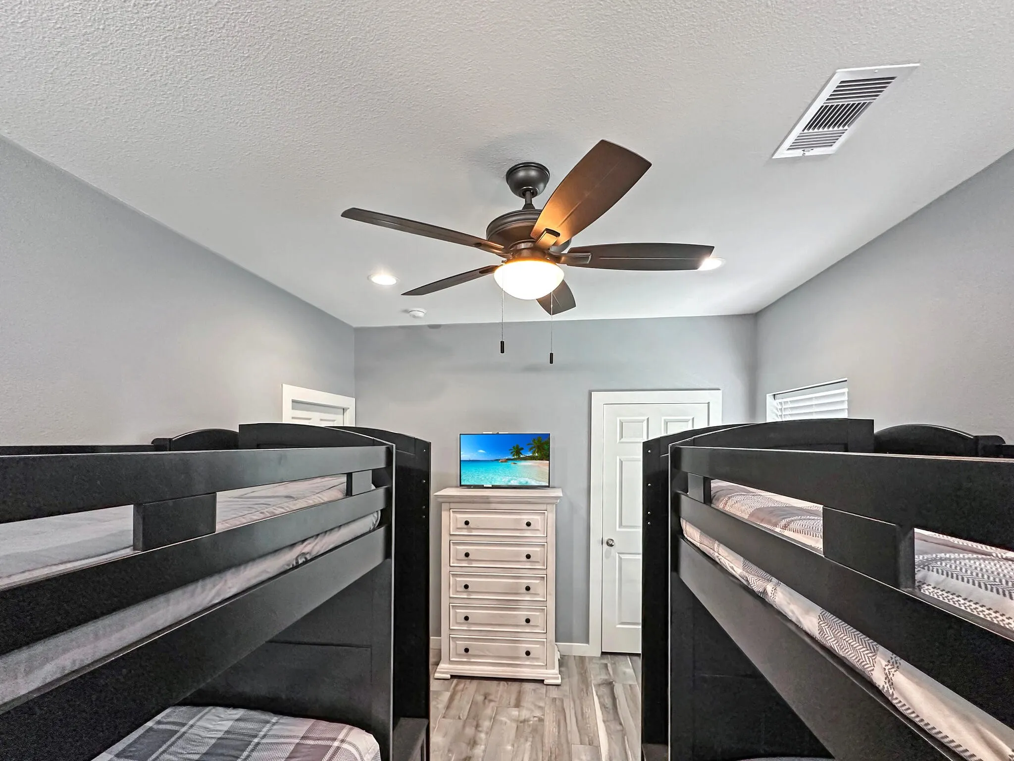Bedroom featuring built in bunkbeds with lights and light wood-style floors