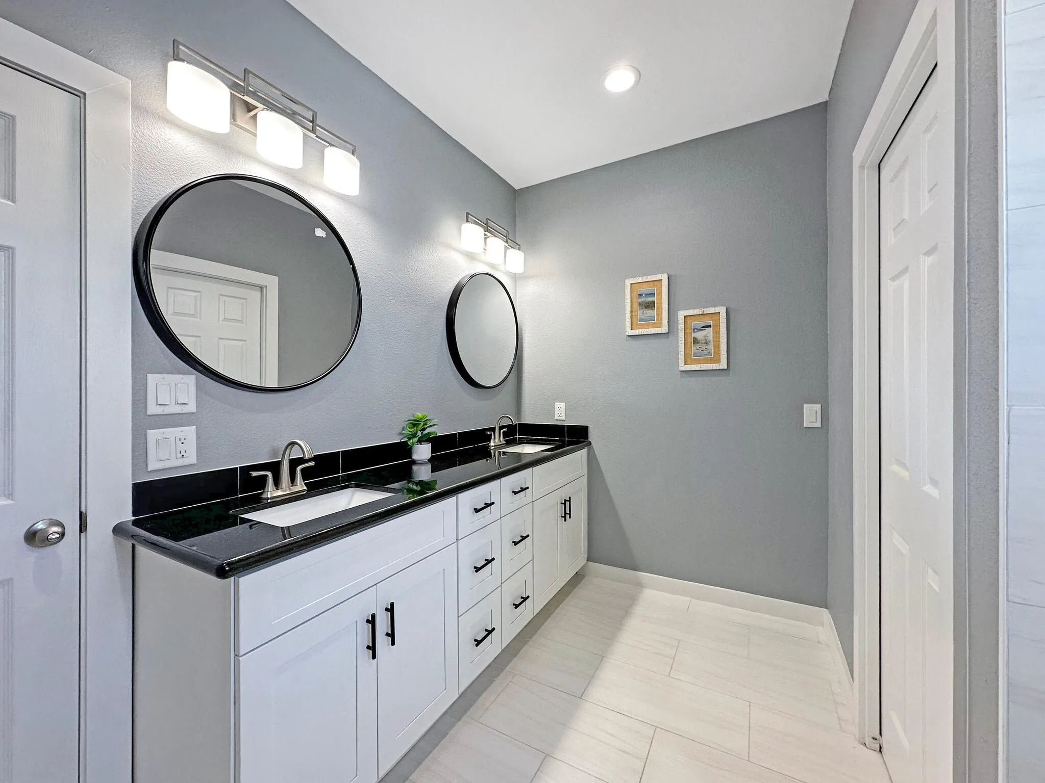 Bathroom with double vanity, baseboards, and a sink