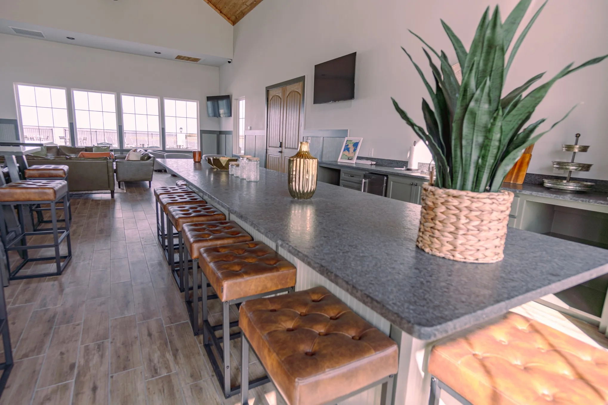 Kitchen featuring a breakfast bar, dark countertops, dark wood finished floors, and high vaulted ceiling