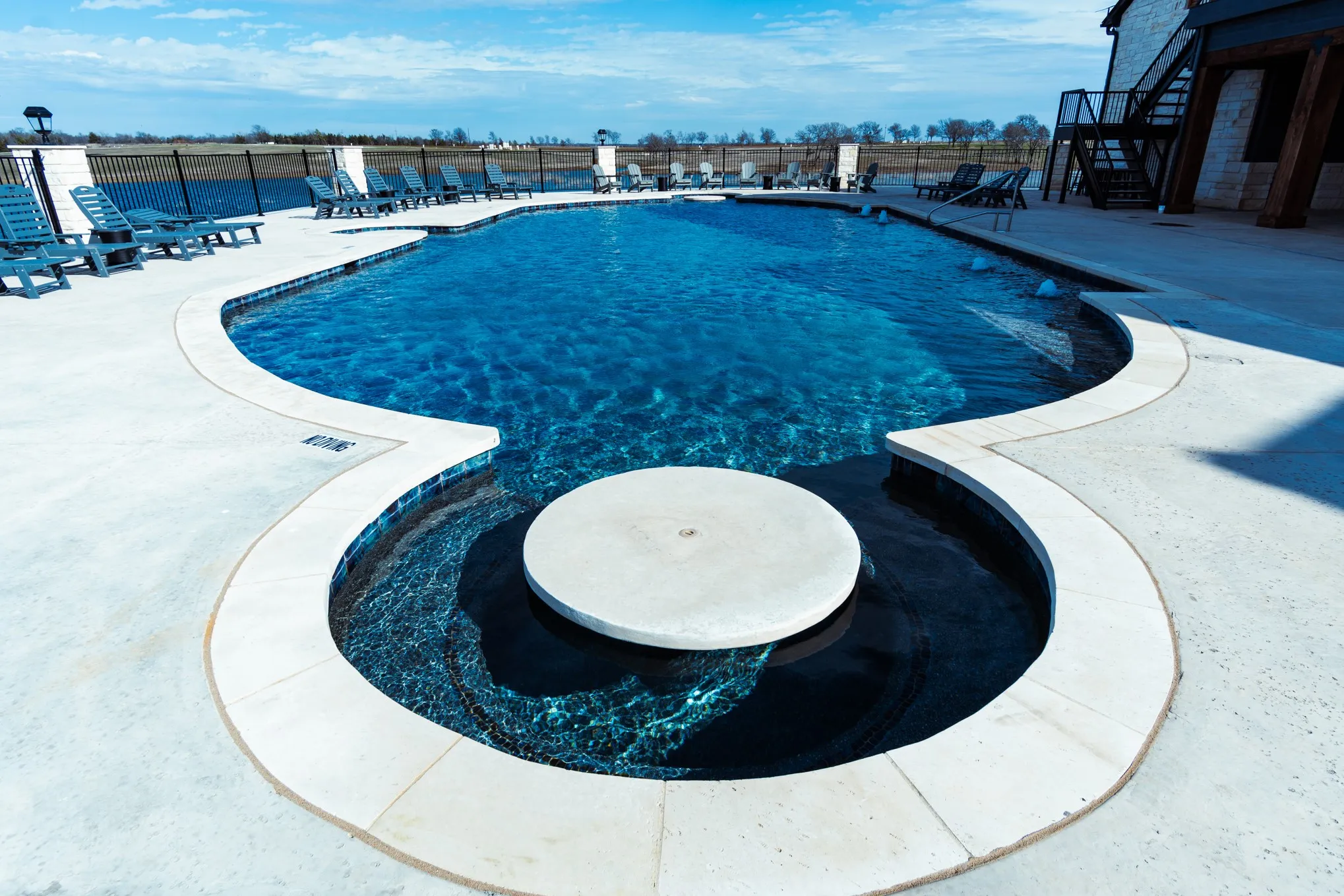 Community pool featuring a patio area, fence, and stairway