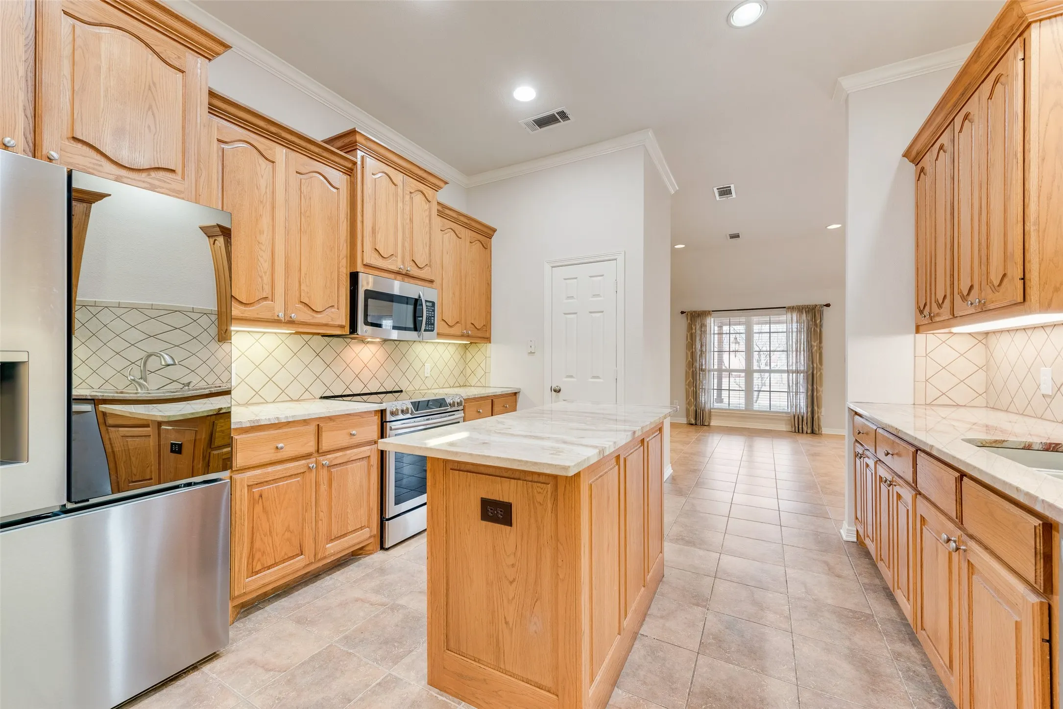 Kitchen with built-in microwave, kitchen island and granite countertops