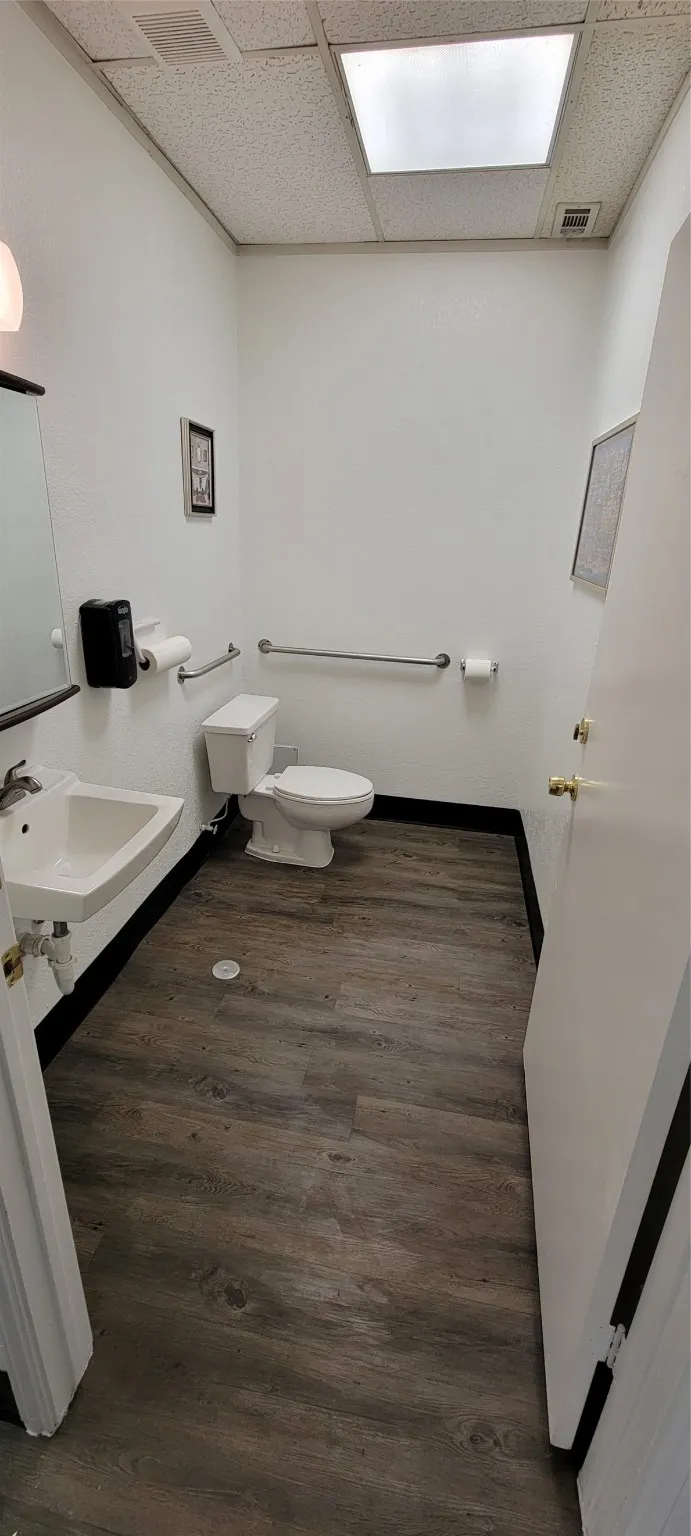 Bathroom  with toilet, vanity, sink, and laminate floor