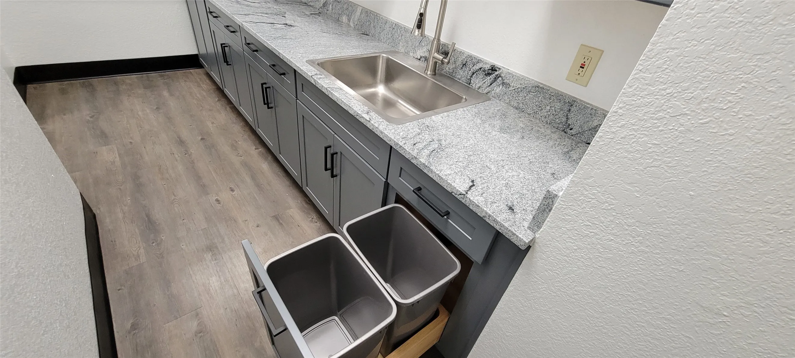 Kitchenette cabinets include built-dual trash cans