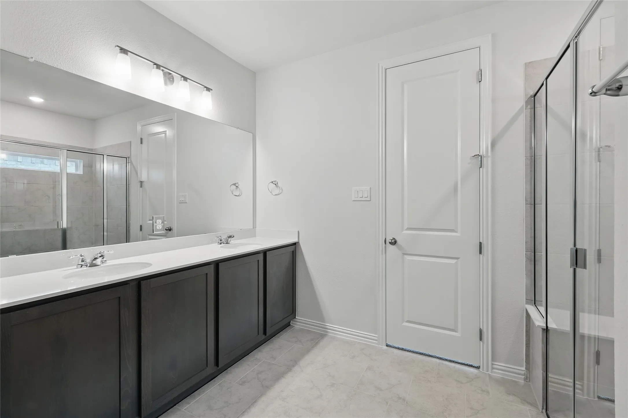 Bathroom with double vanity and a stall shower
