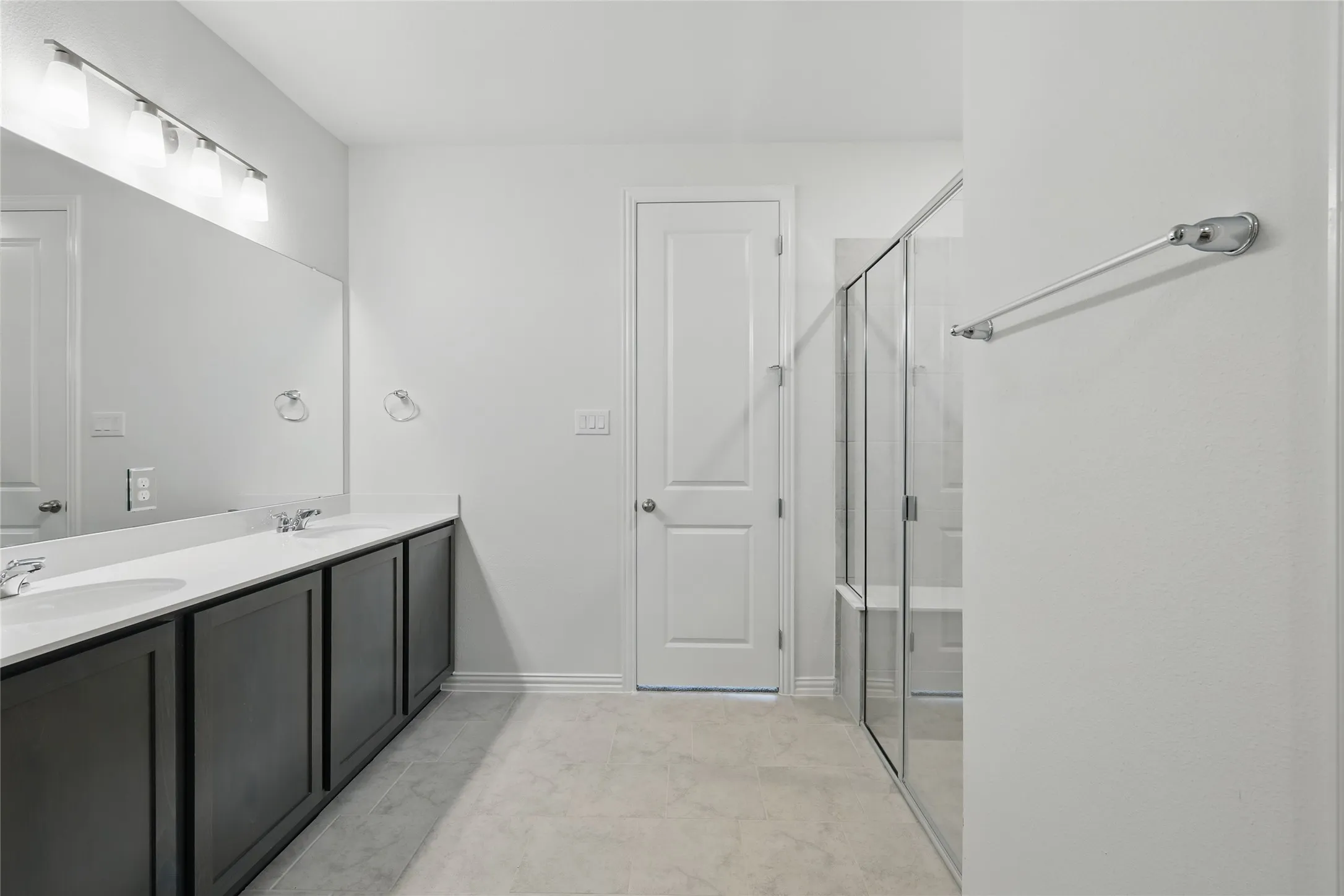 Full bath featuring double vanity and a shower stall