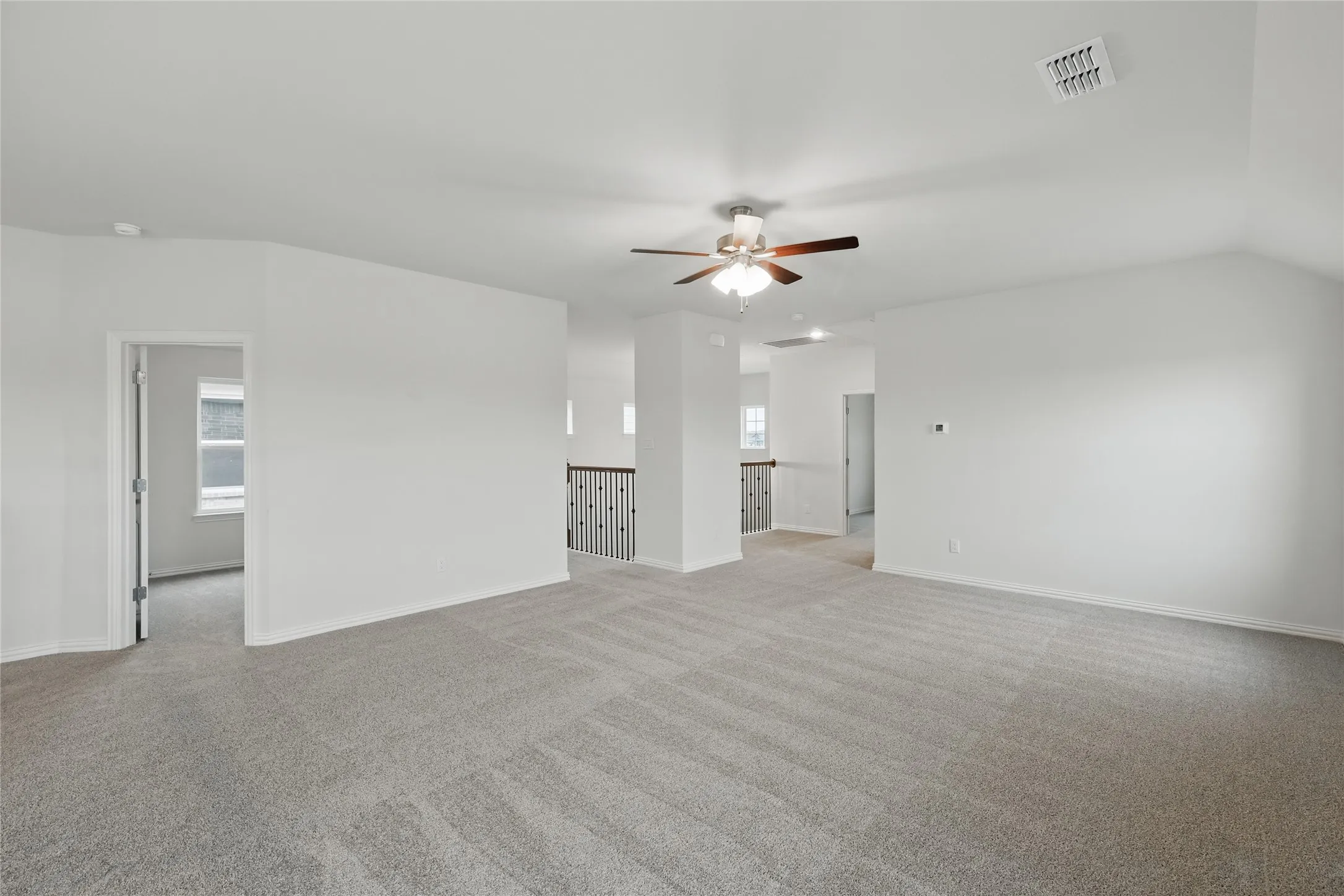 Unfurnished living room with light carpet and ceiling fan