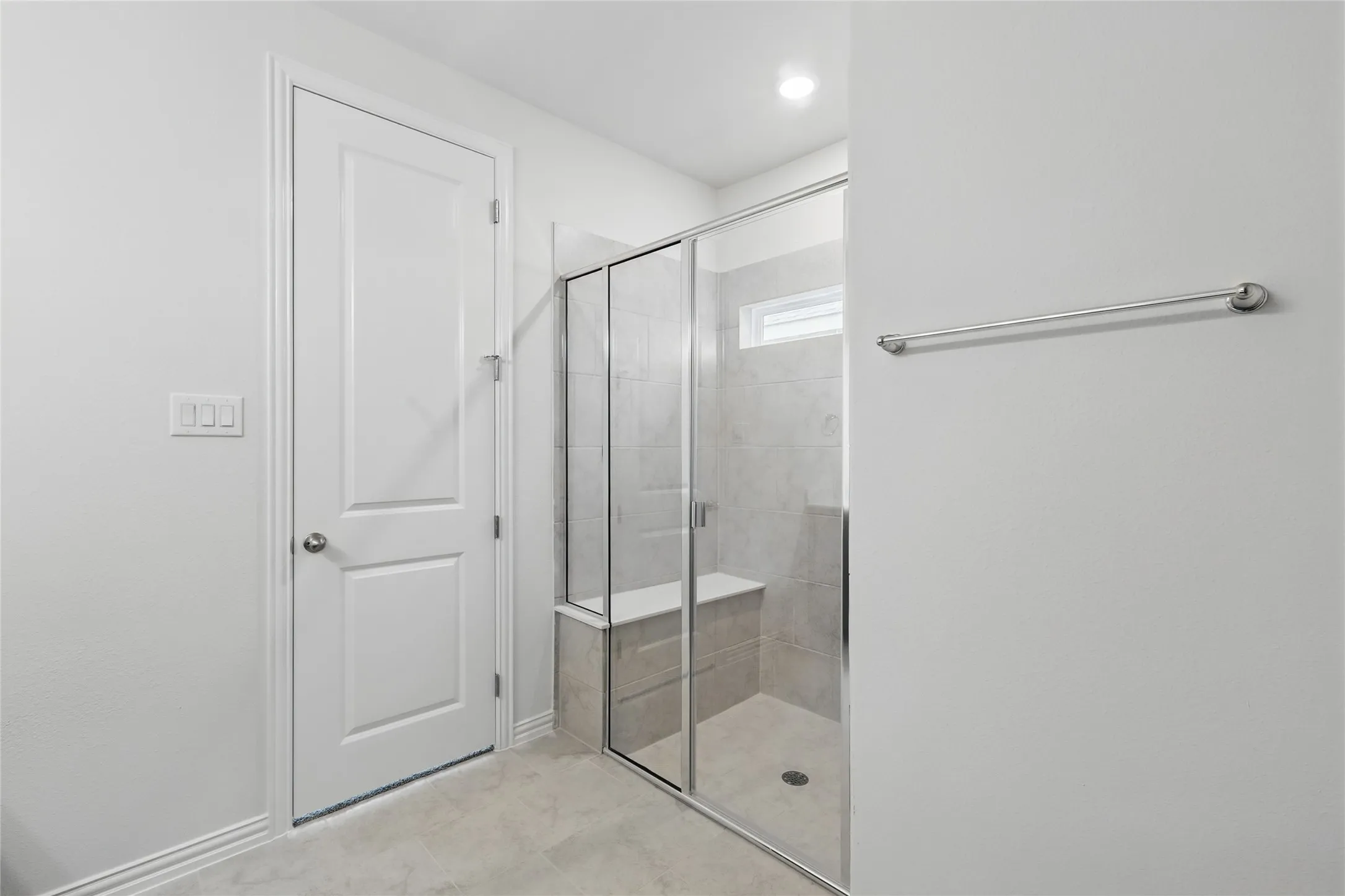 Bathroom with a shower stall and baseboards