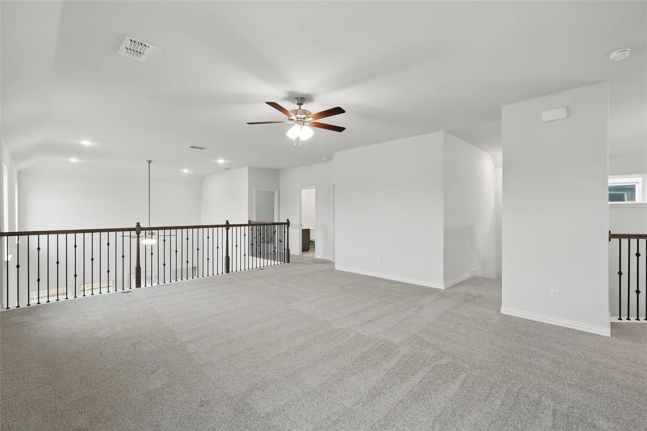 Carpeted spare room featuring a ceiling fan and baseboards