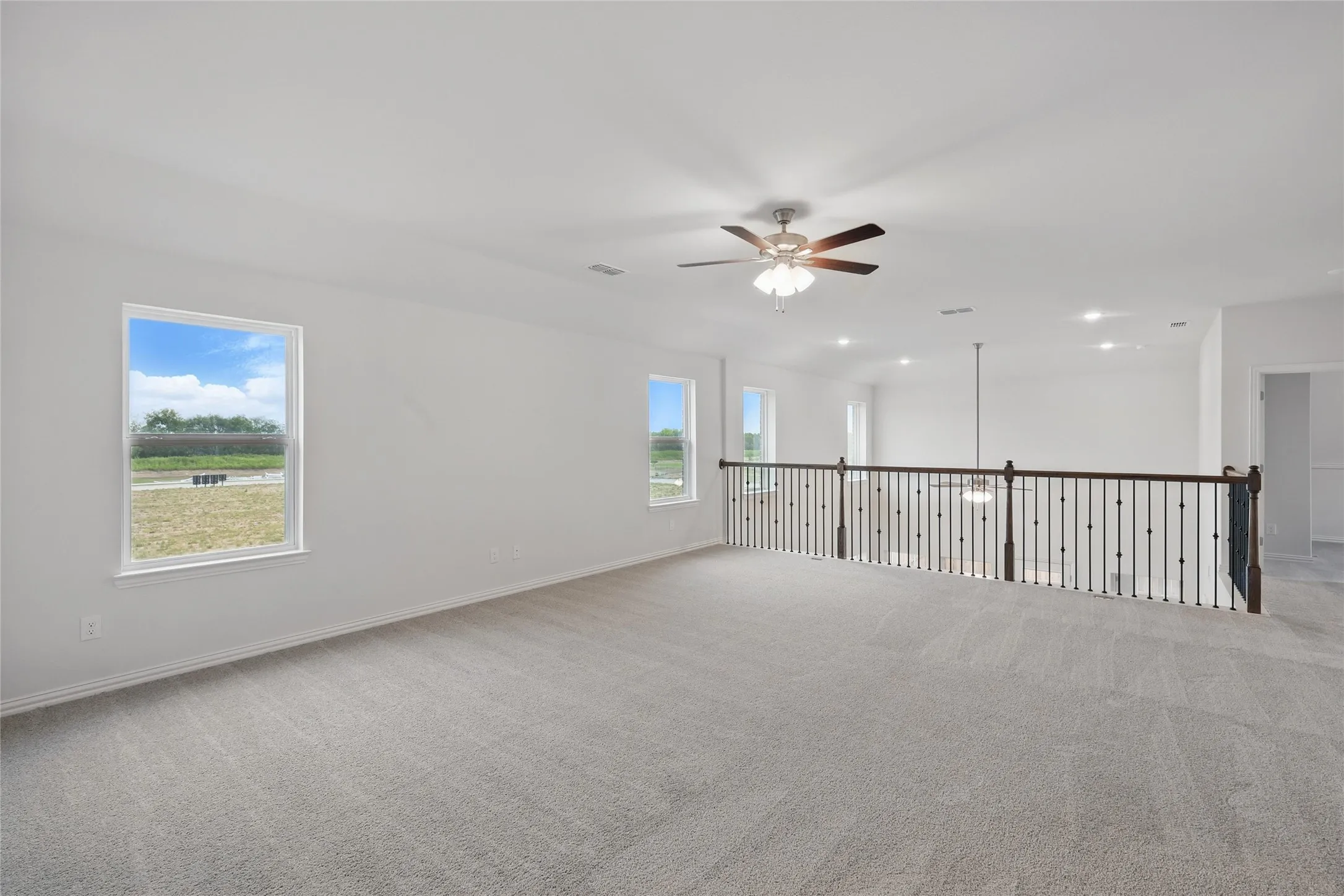 Spare room with light colored carpet and ceiling fan