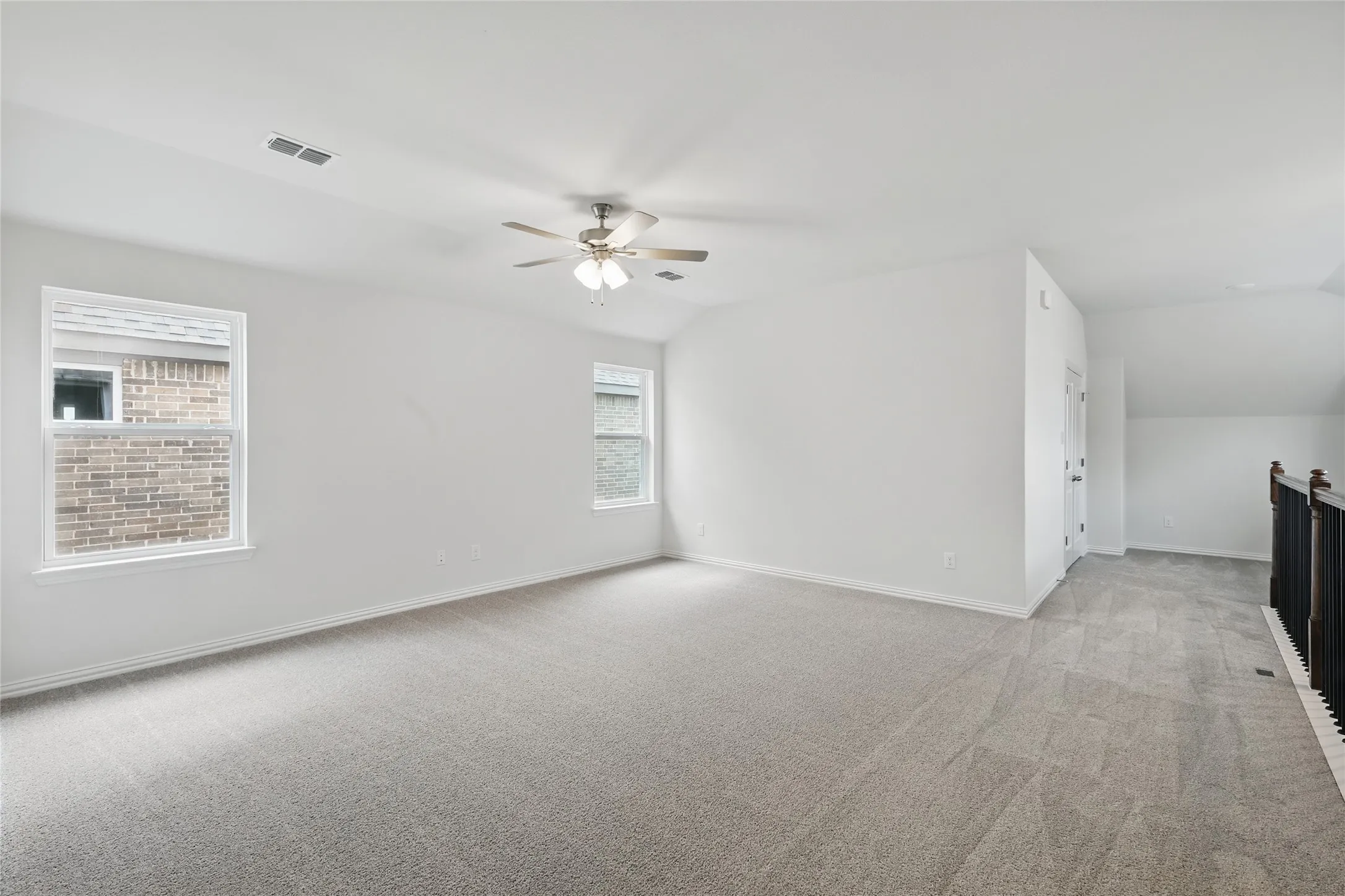 Unfurnished room featuring lofted ceiling, light carpet, and a ceiling fan