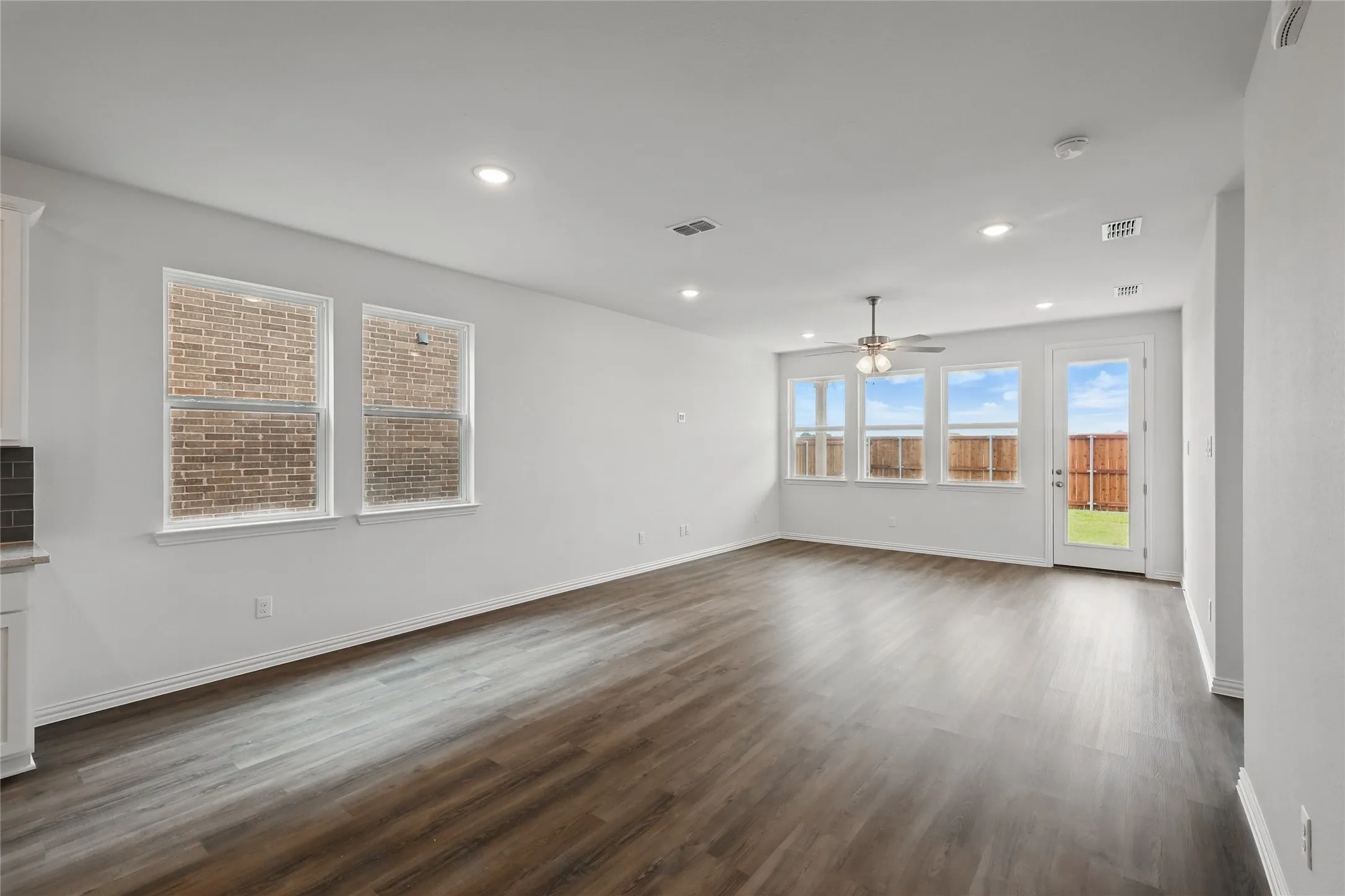 Unfurnished living room featuring dark wood-type flooring, recessed lighting, and a ceiling fan