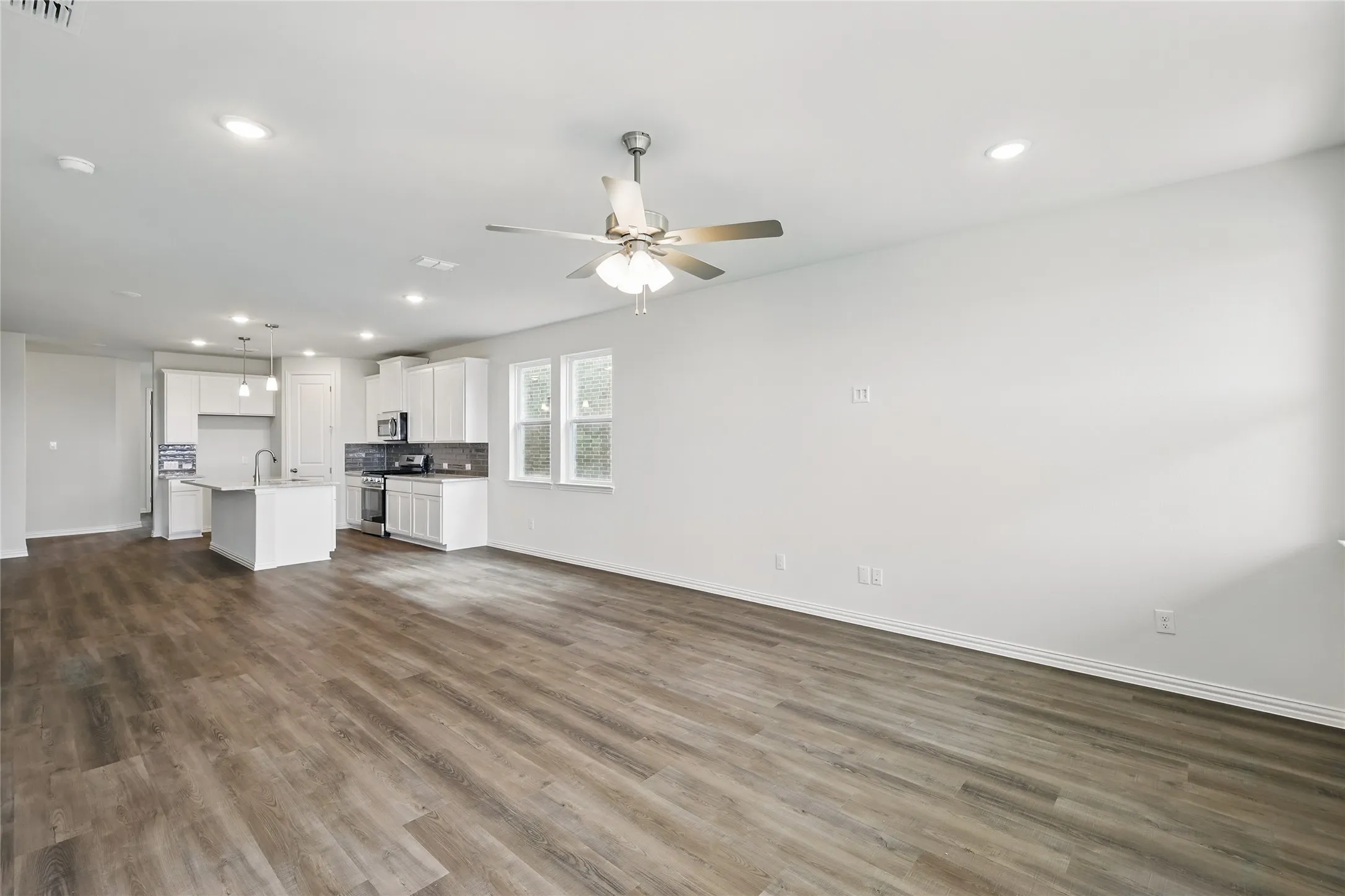 Unfurnished living room with recessed lighting, dark wood-style flooring, and a ceiling fan