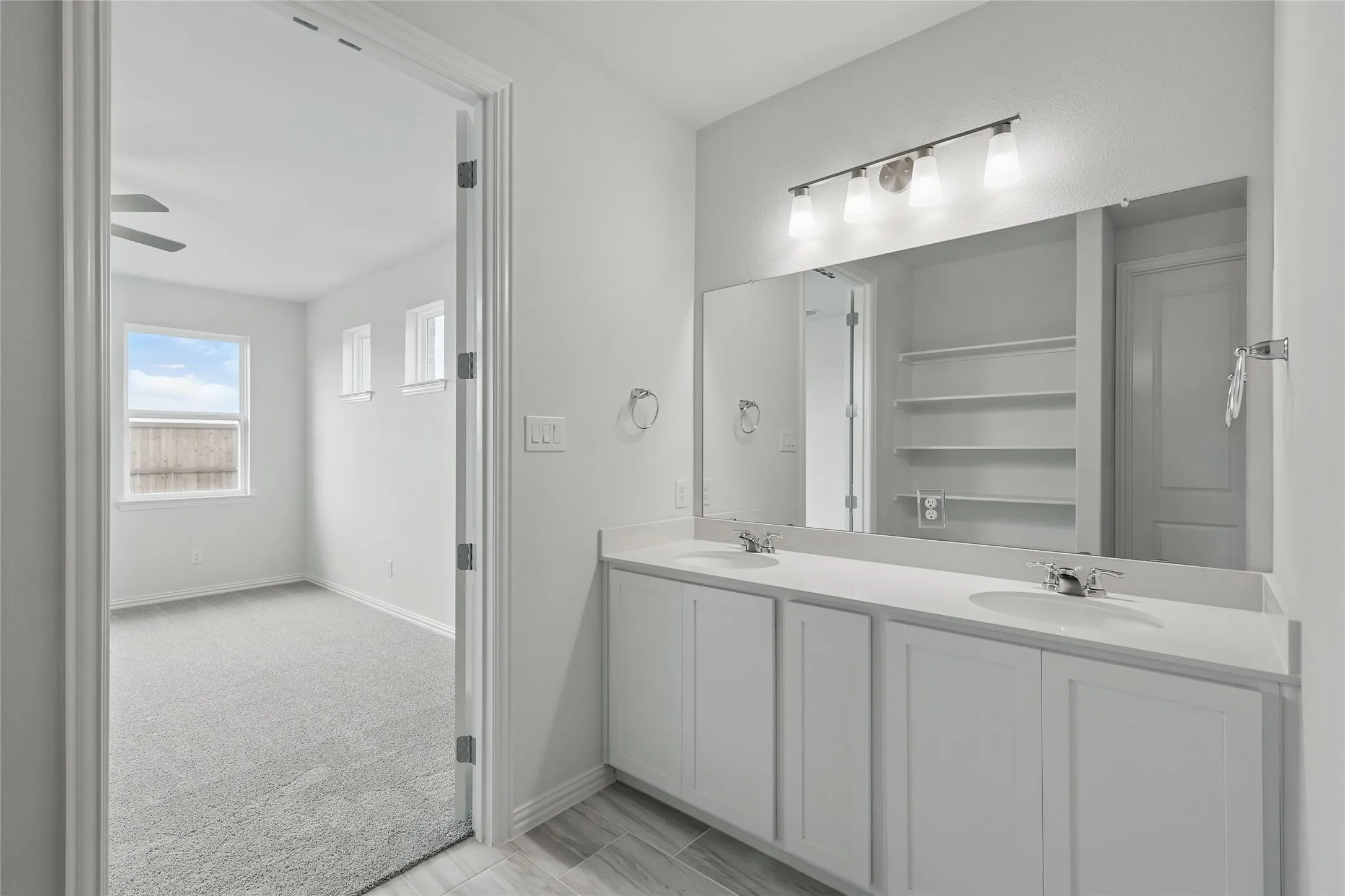 Full bathroom featuring double vanity and baseboards