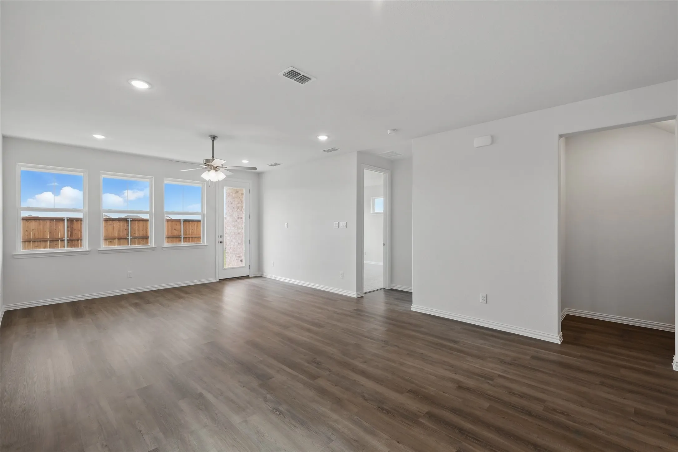 Unfurnished living room featuring dark wood-style flooring, recessed lighting, and ceiling fan