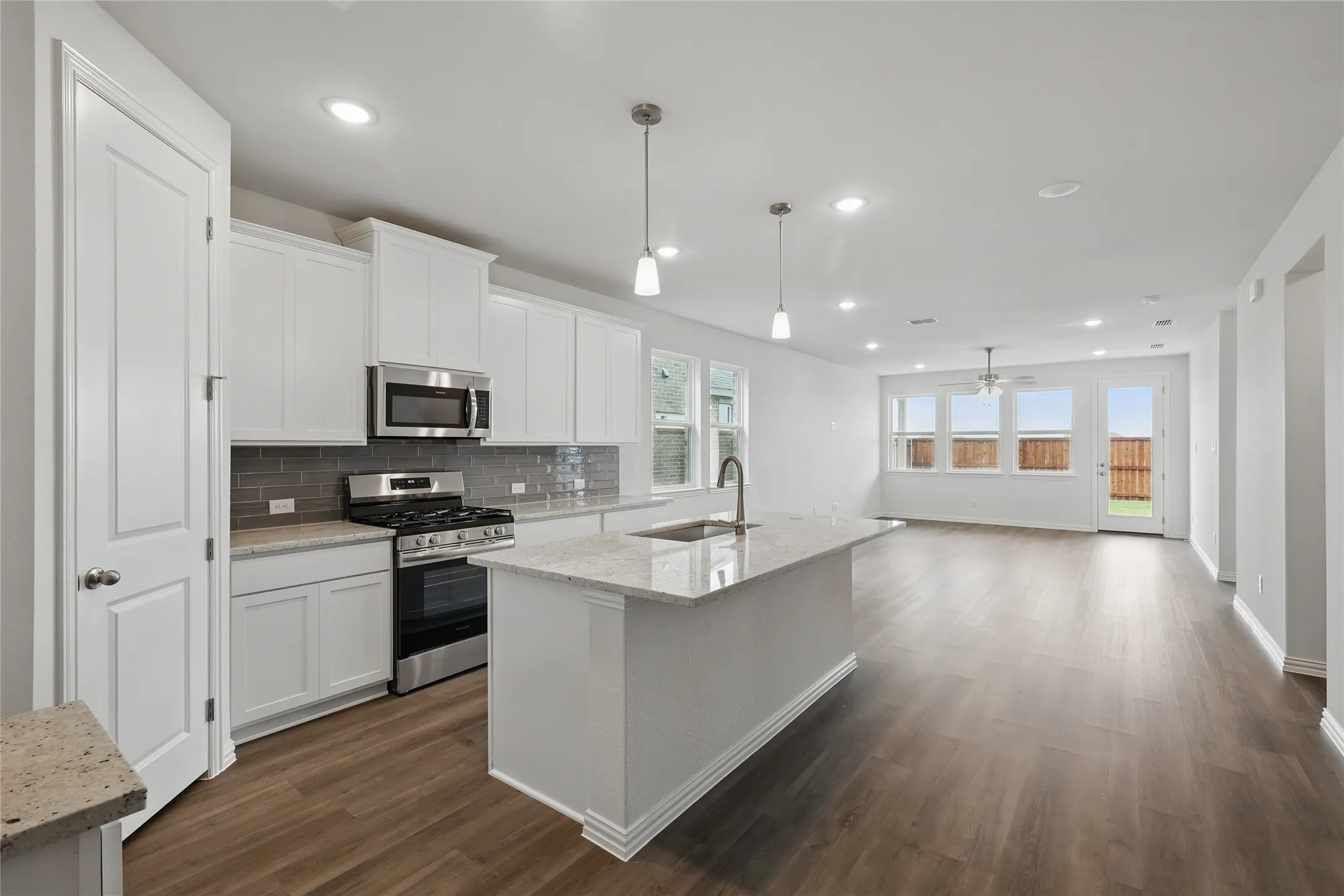 Kitchen with appliances with stainless steel finishes, tasteful backsplash, white cabinetry, ceiling fan, and recessed lighting