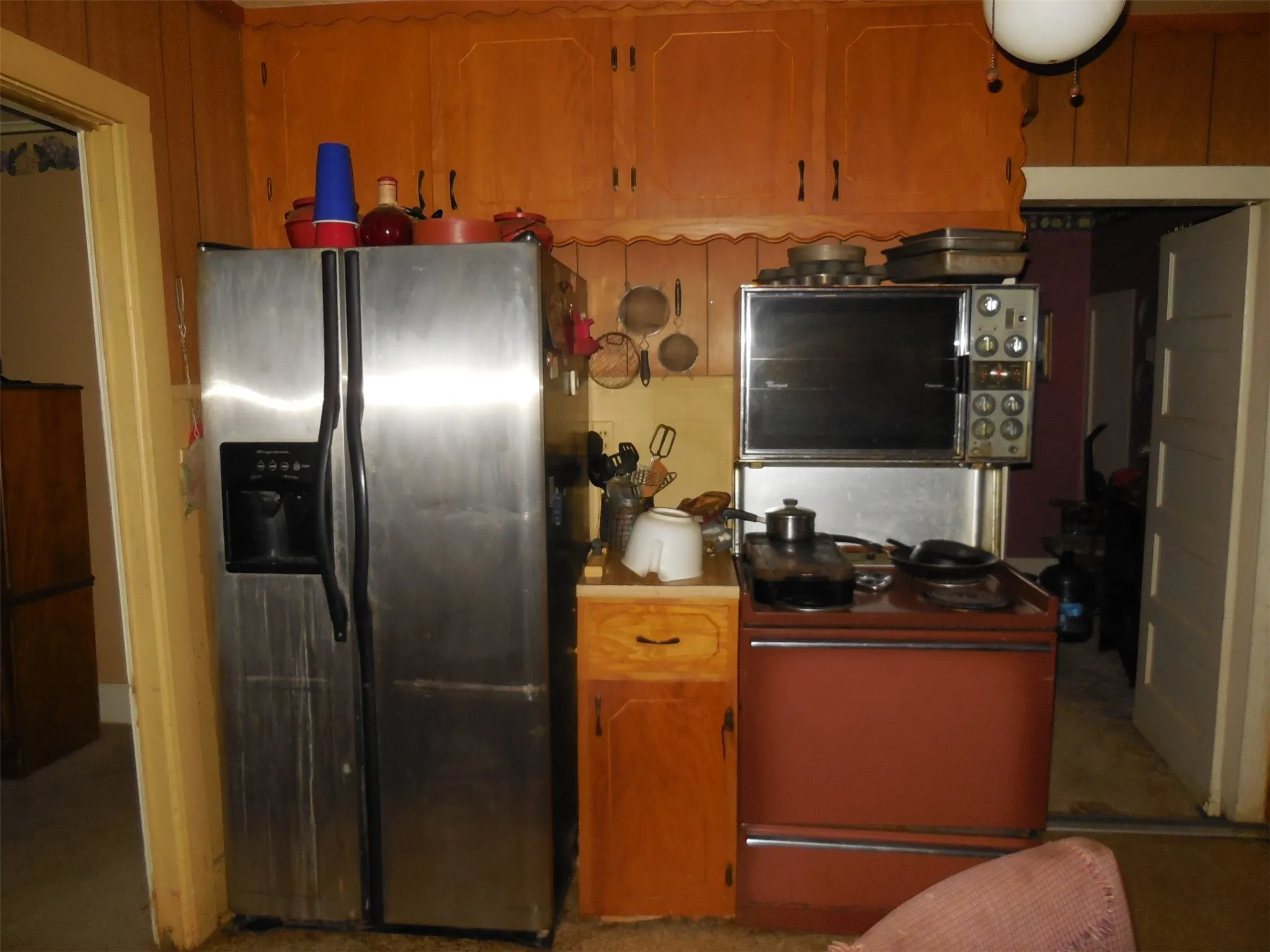 Kitchen with range with electric cooktop, stainless steel refrigerator with ice dispenser, and light countertops