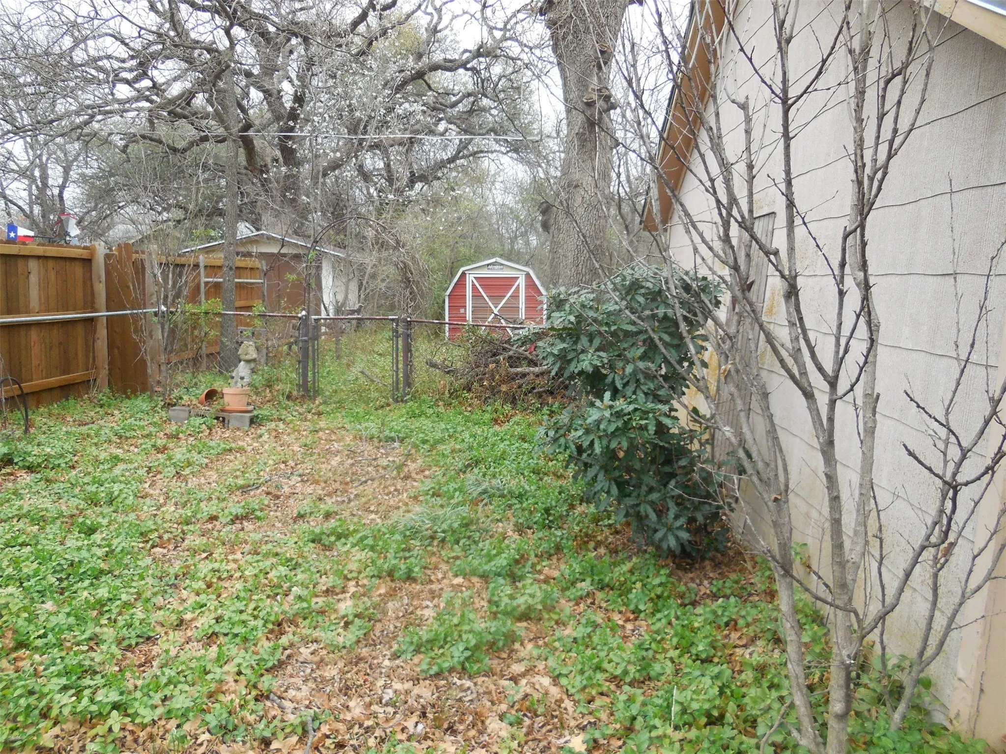 View of yard with a storage shed, fence, and an outdoor structure