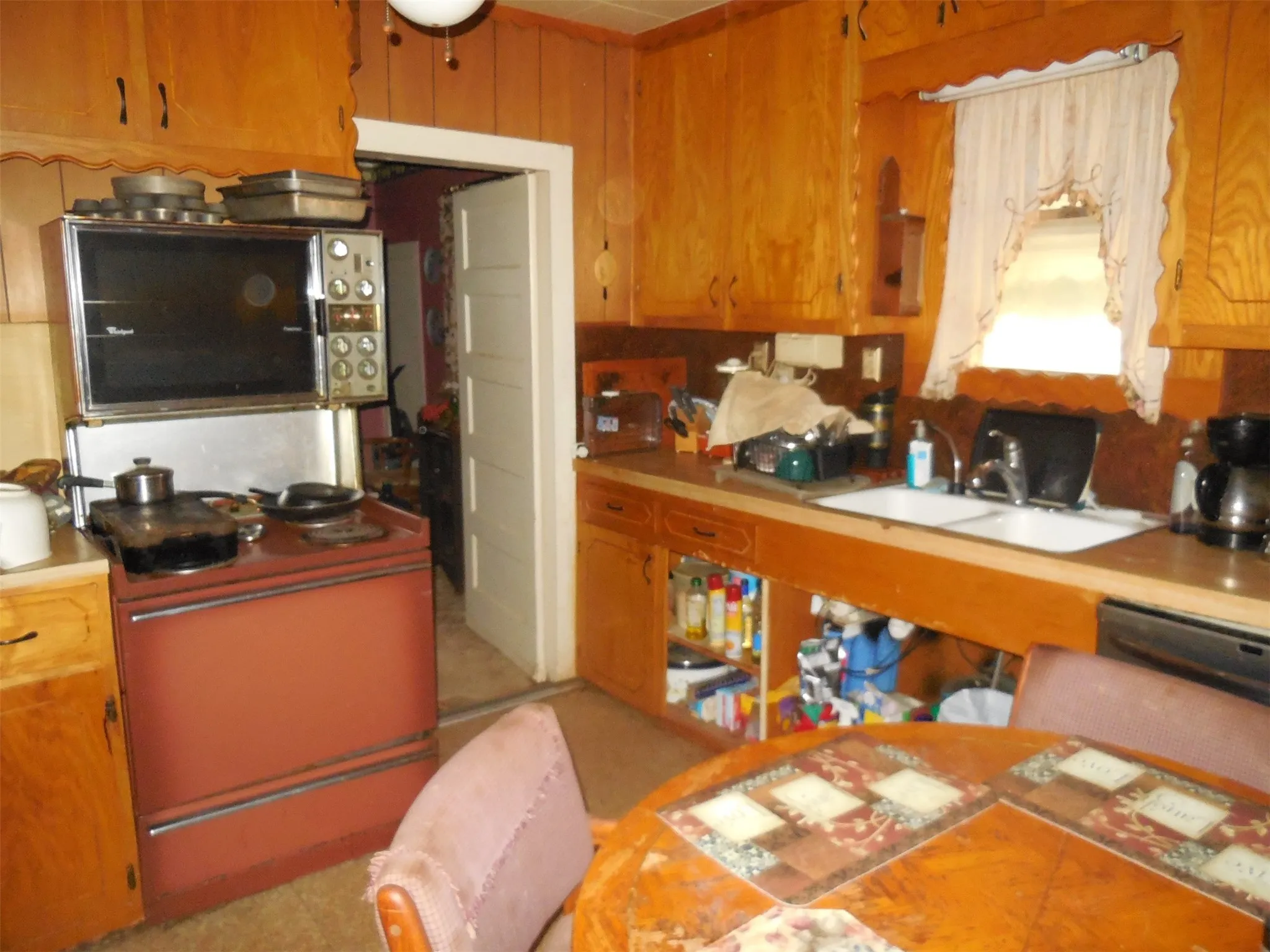 Kitchen with light countertops, brown cabinetry, and a sink