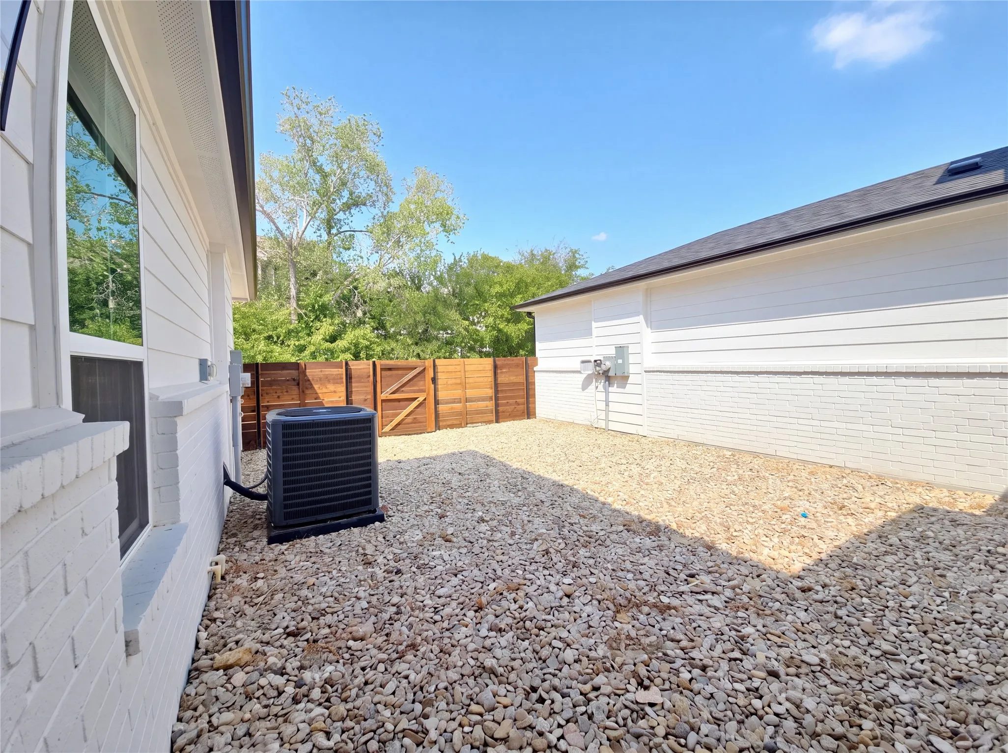 White painted brick and horizontal siding exterior with dark shingle roofing