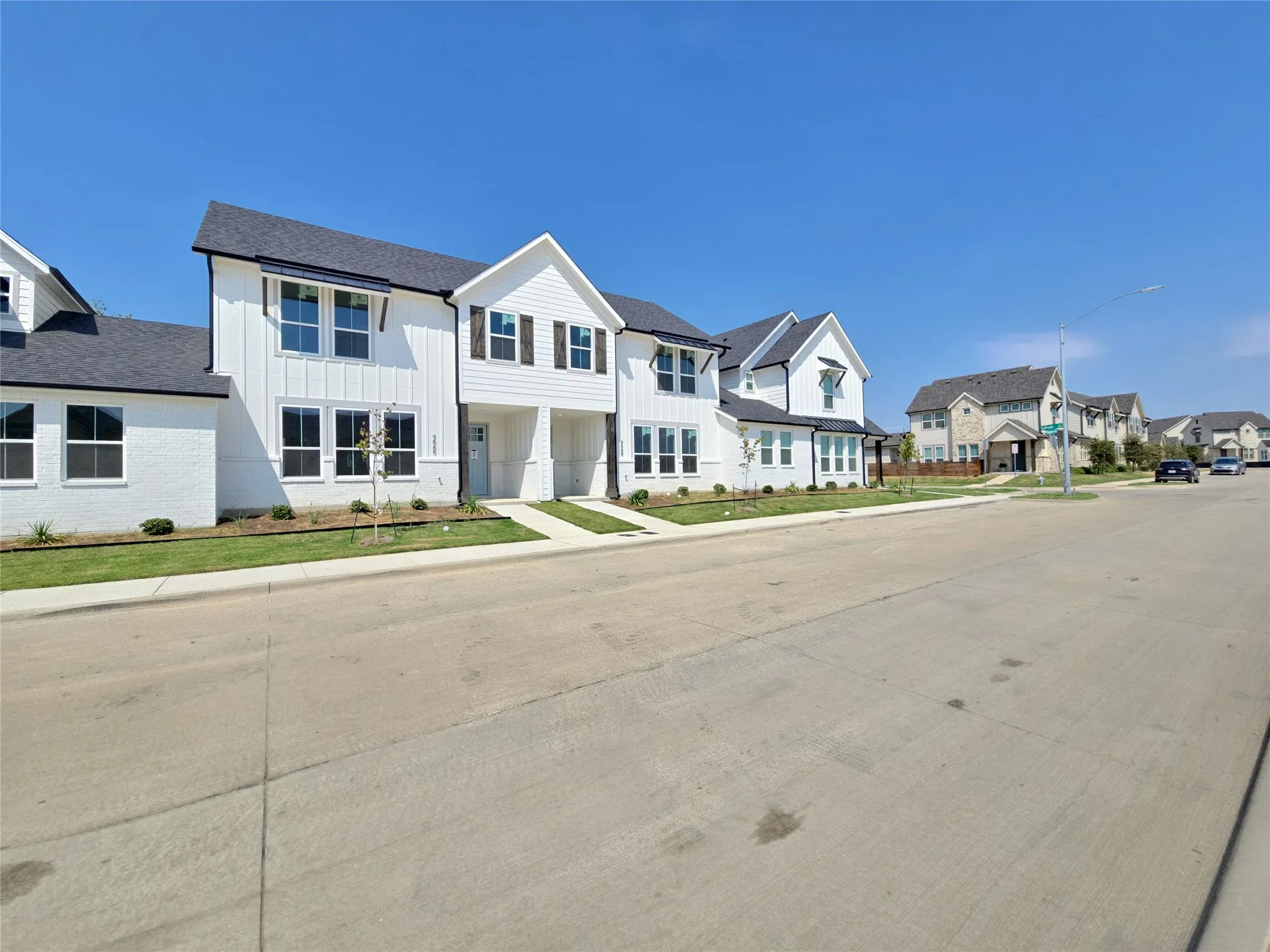 Modern farmhouse-style exterior featuring white brick and vertical siding