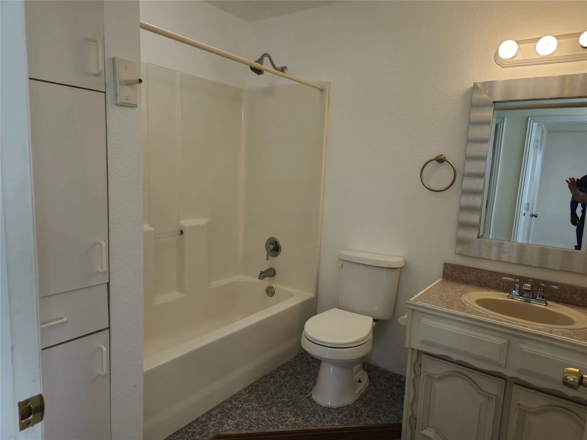 Bathroom with washtub / shower combination, toilet, and vanity