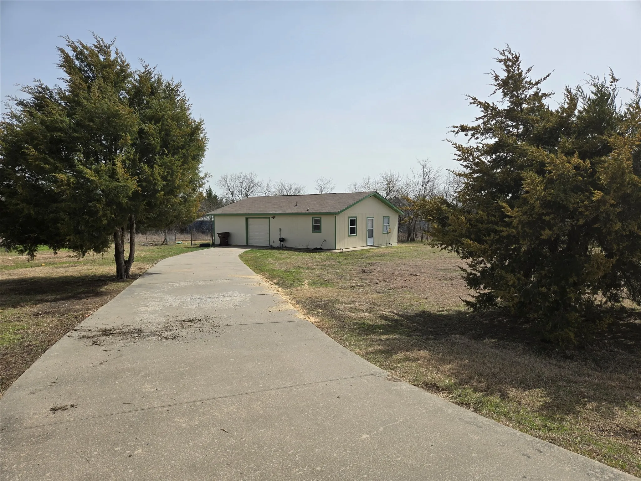 View of front facade with concrete driveway, a garage, and a front yard
