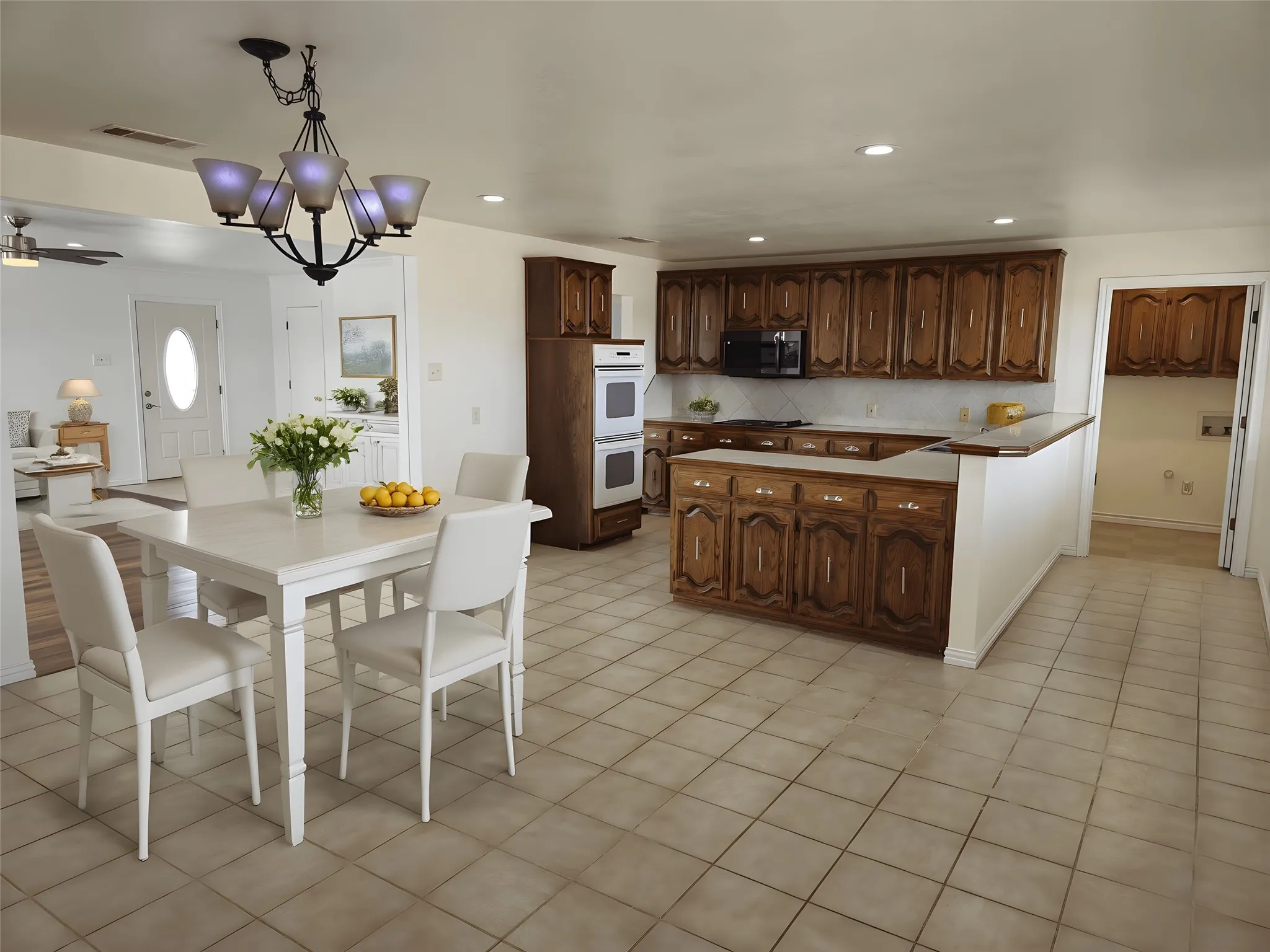 Kitchen with a peninsula, hanging light fixtures, a chandelier, backsplash, and recessed lighting