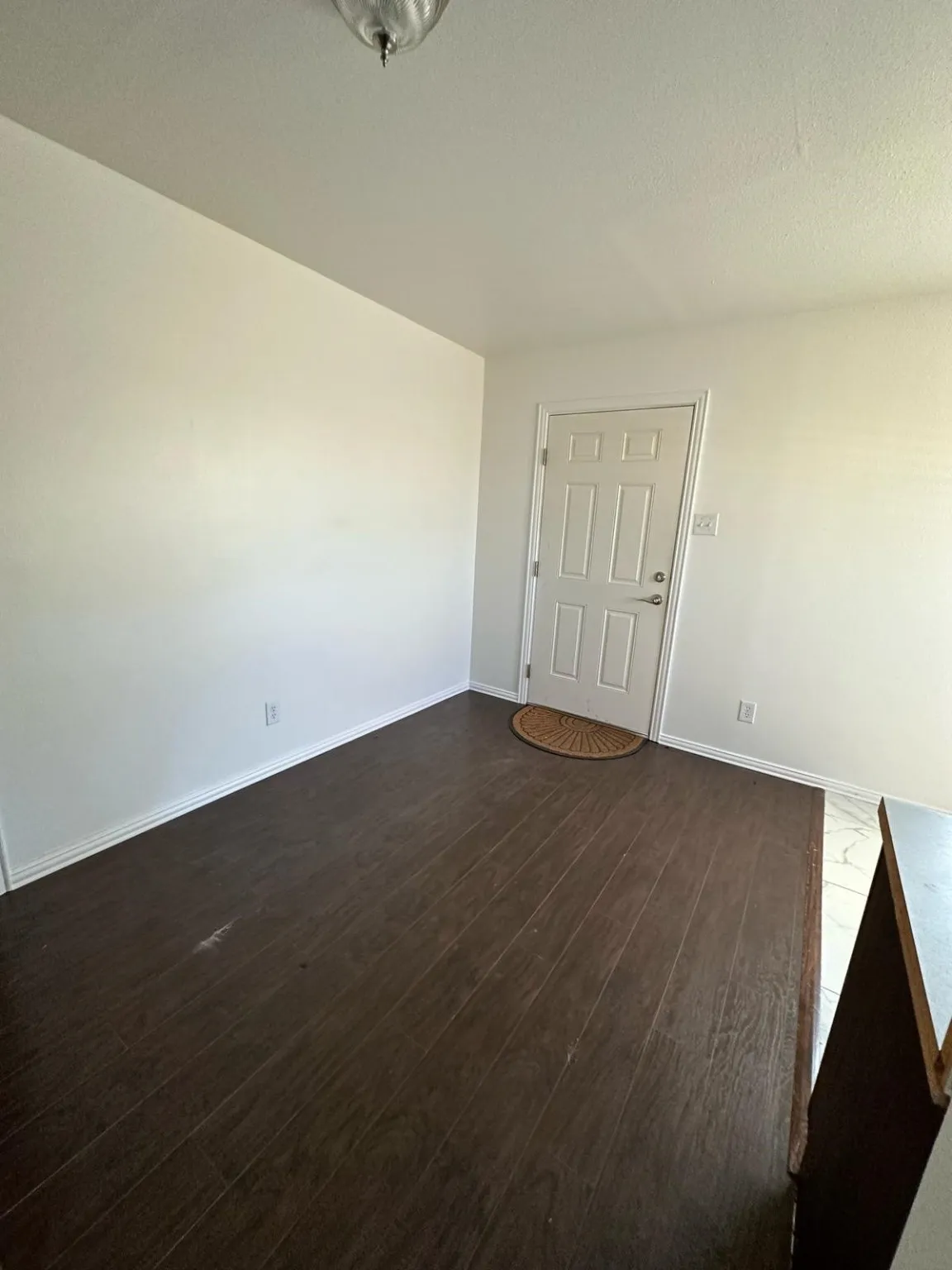 Spare room featuring dark wood finished floors and a textured ceiling