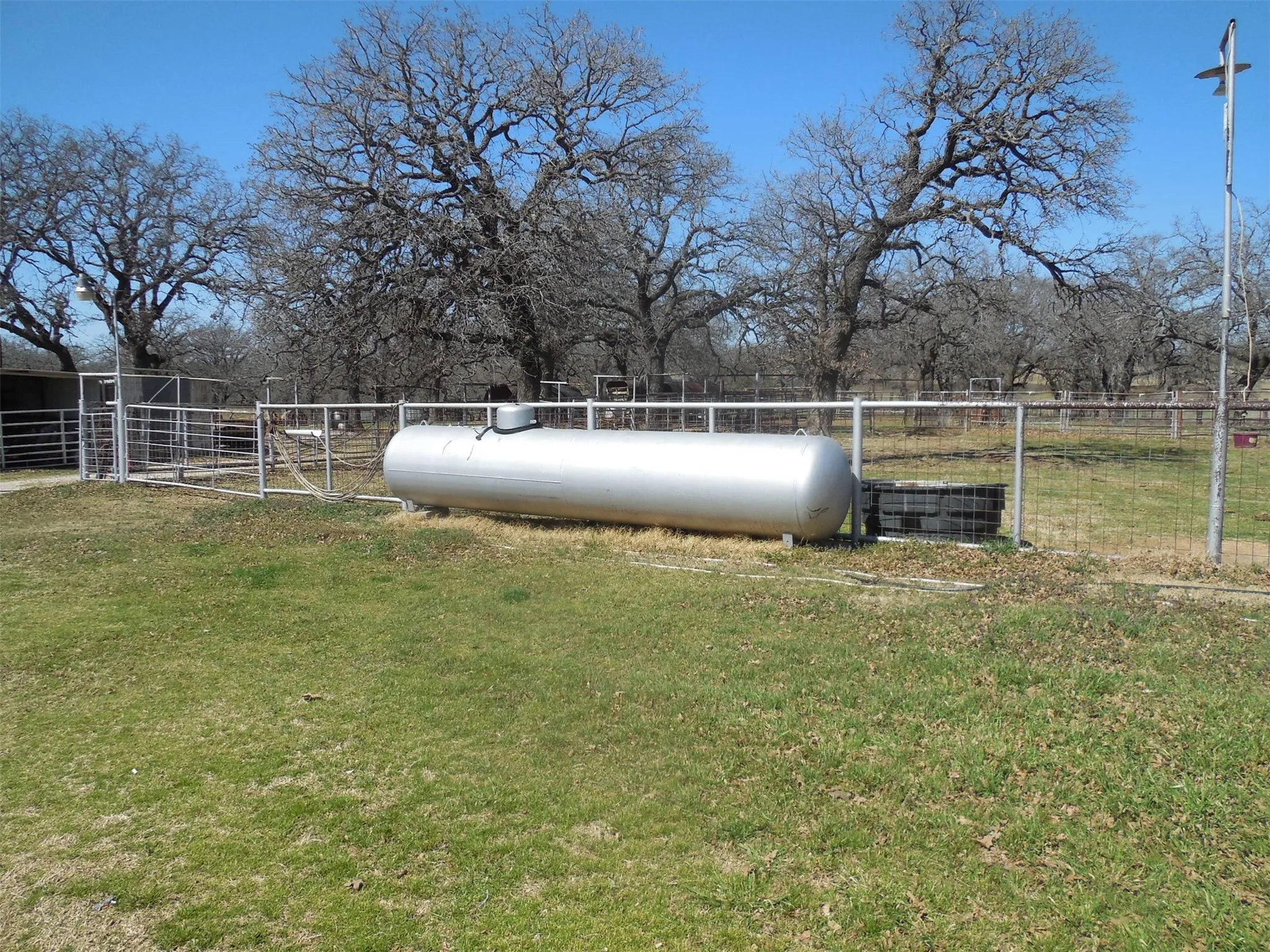View of yard with a rural view, propane tank and fence