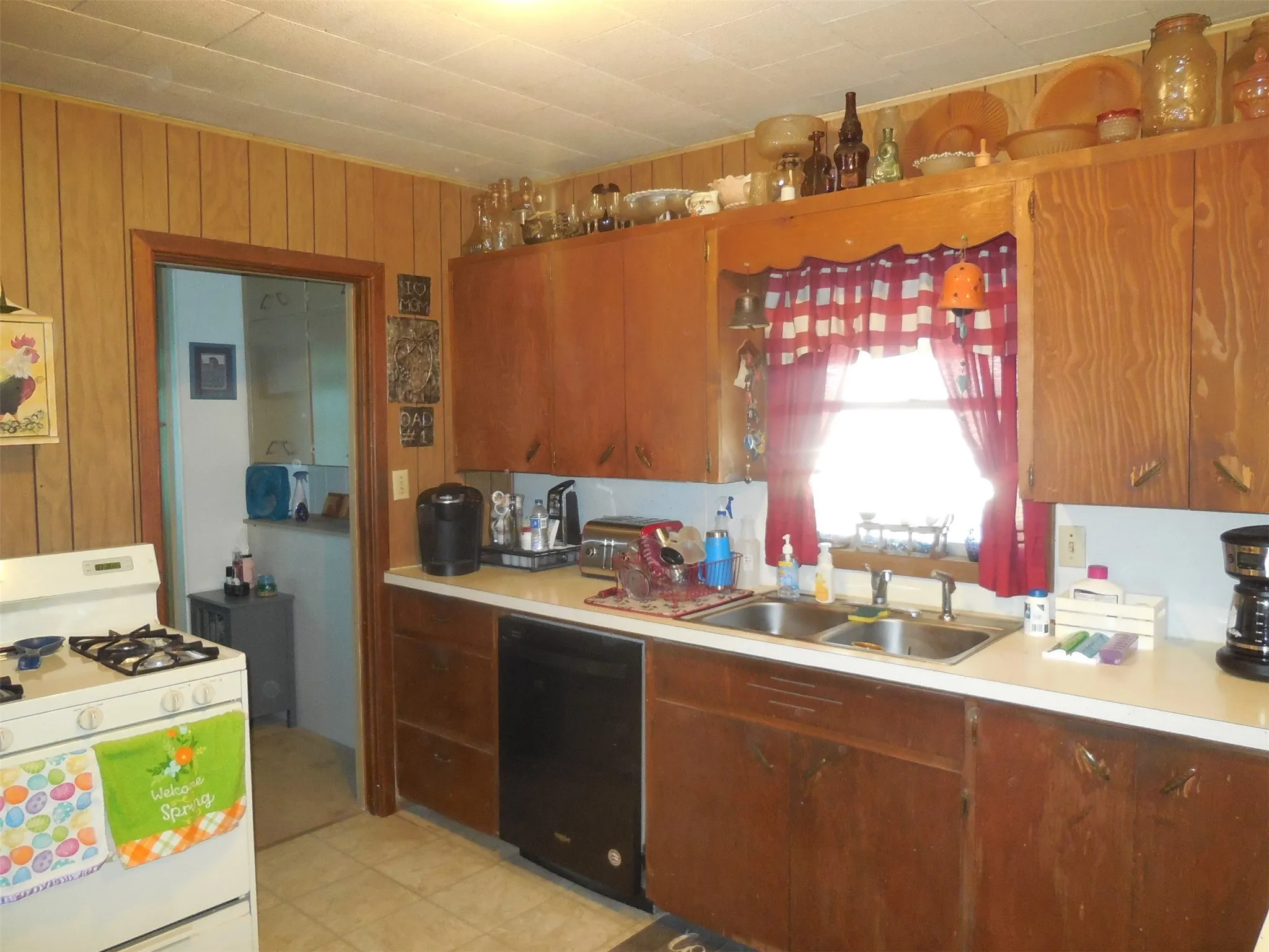 Kitchen featuring a sink, dishwasher, white gas stove, and light countertops
