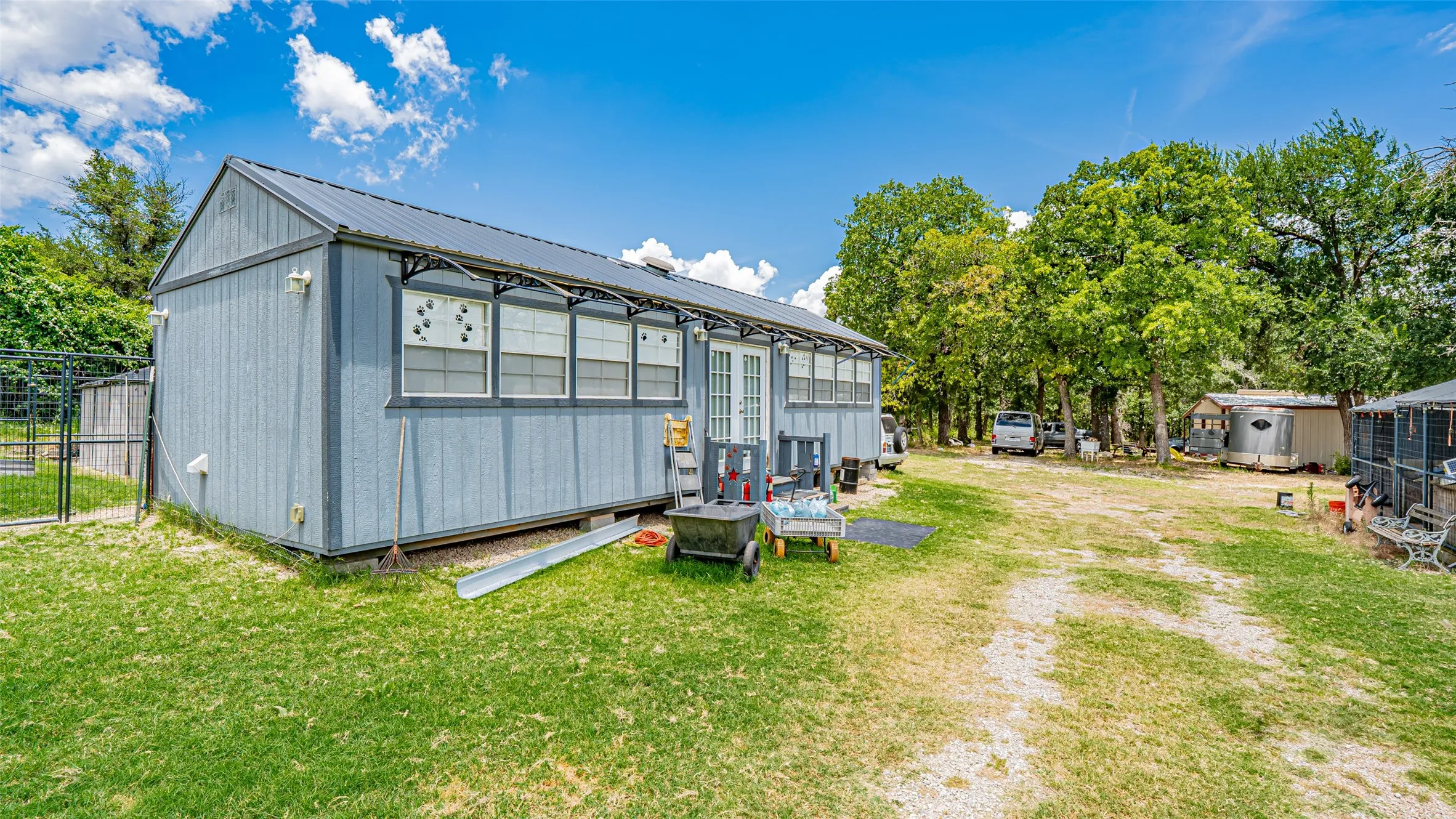 Rear view of property featuring a metal roof and a storage unit
