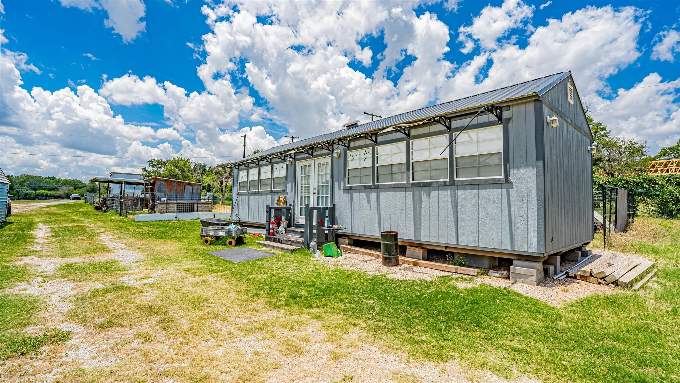 Rear view of property with a lawn and a metal roof