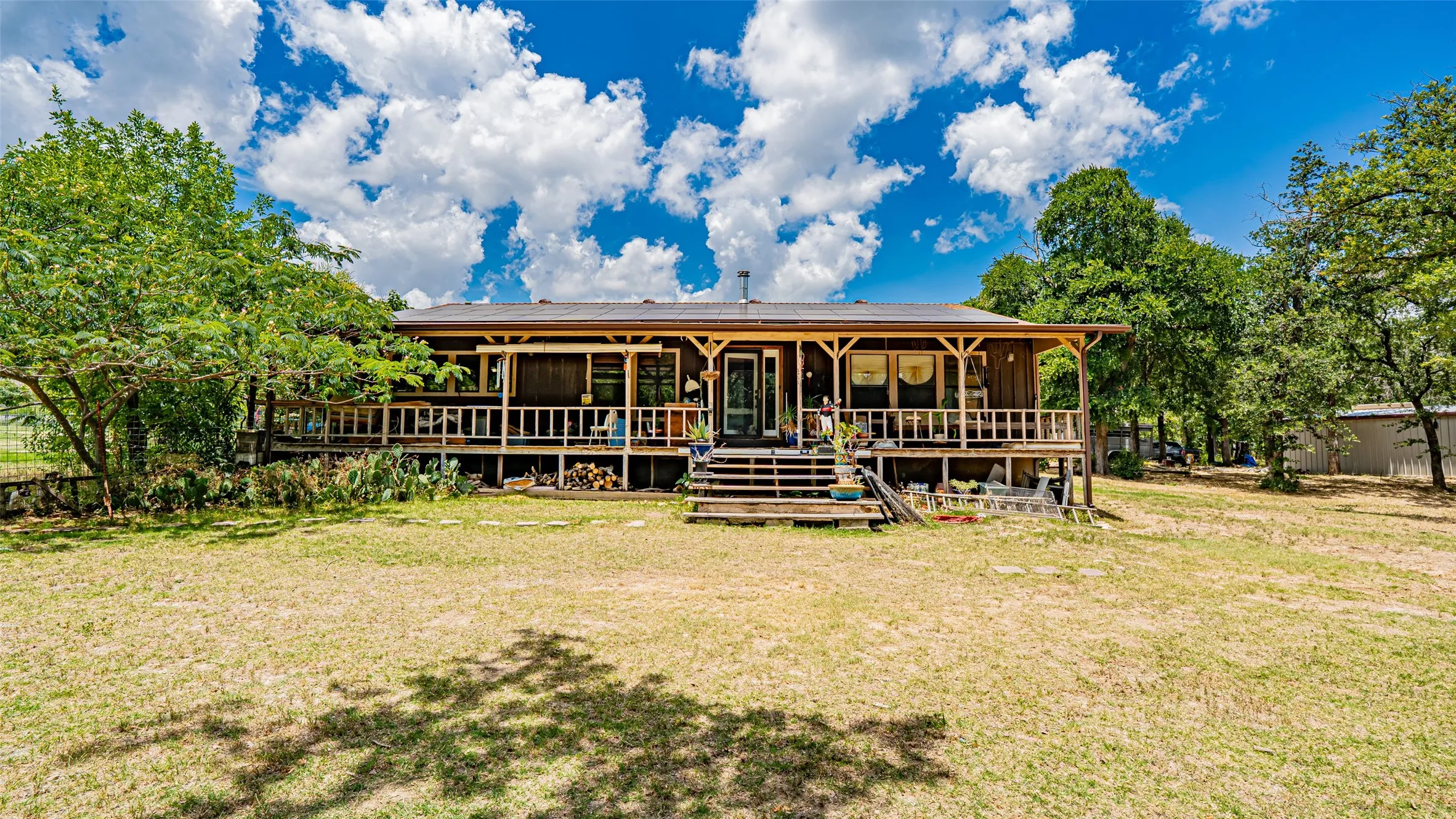 Back of property featuring a lawn and a wooden deck