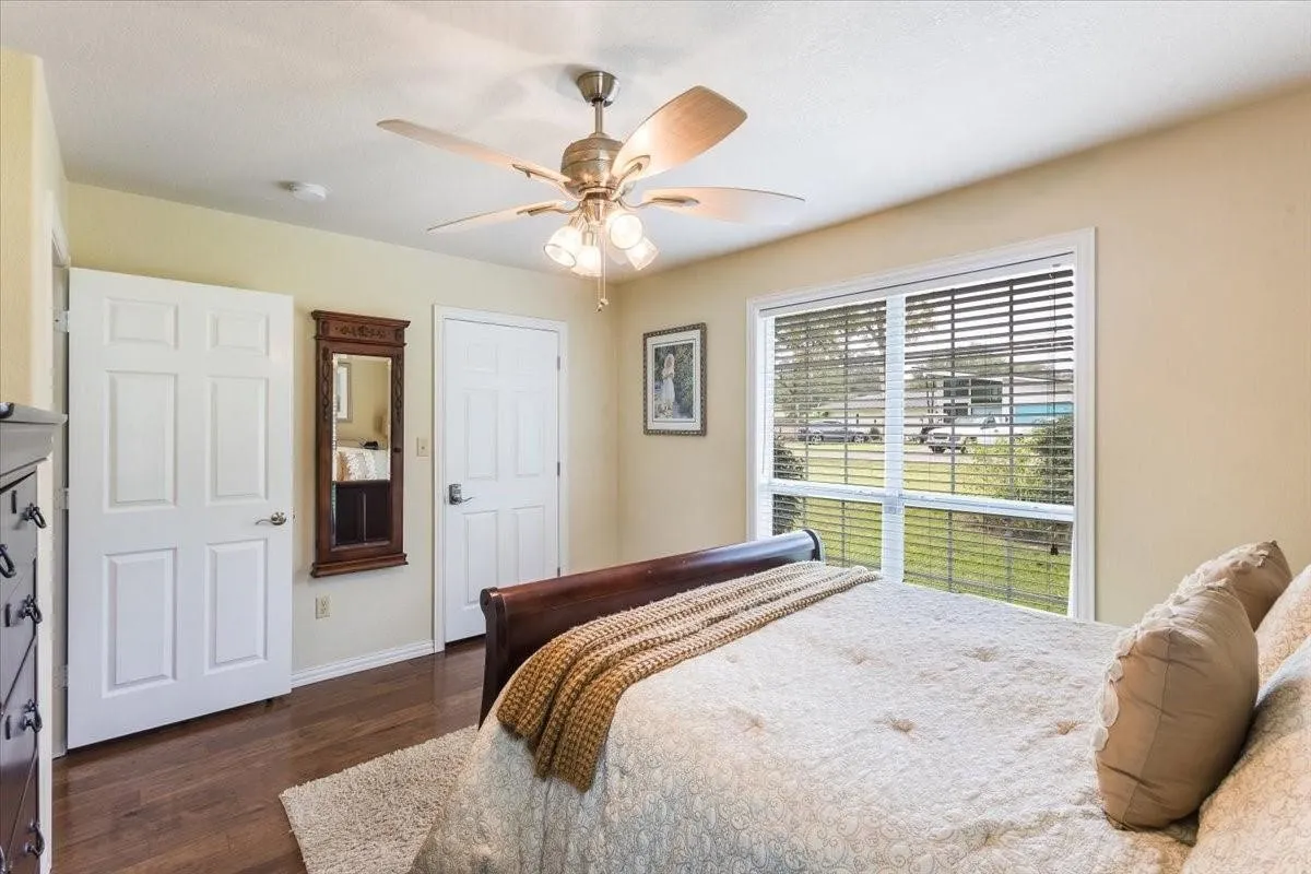 Bedroom with dark wood-type flooring, ceiling fan, and baseboards