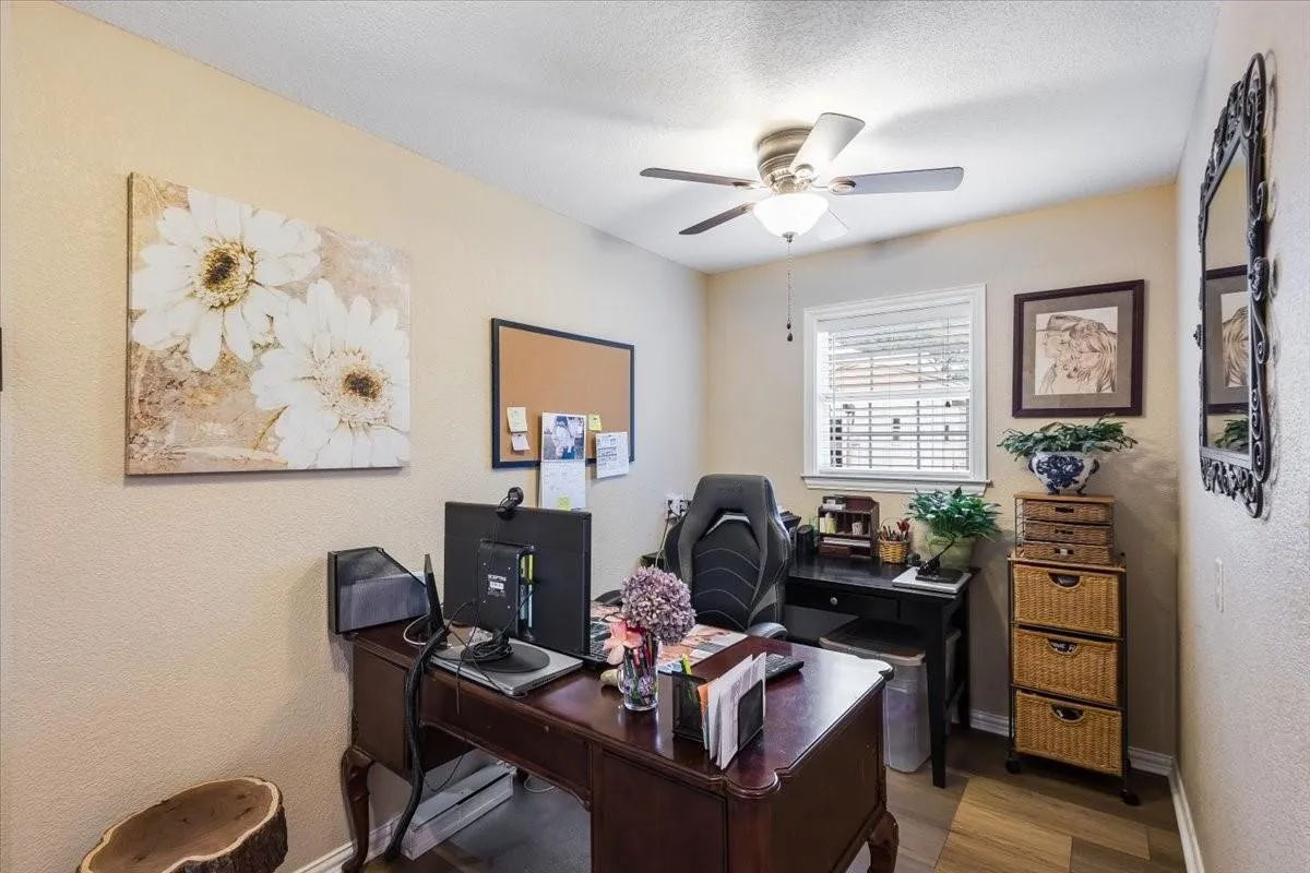 Home office with ceiling fan, a textured ceiling, baseboards, and wood finished floors