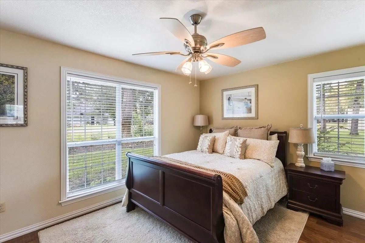 Bedroom with ceiling fan, baseboards, and wood finished floors